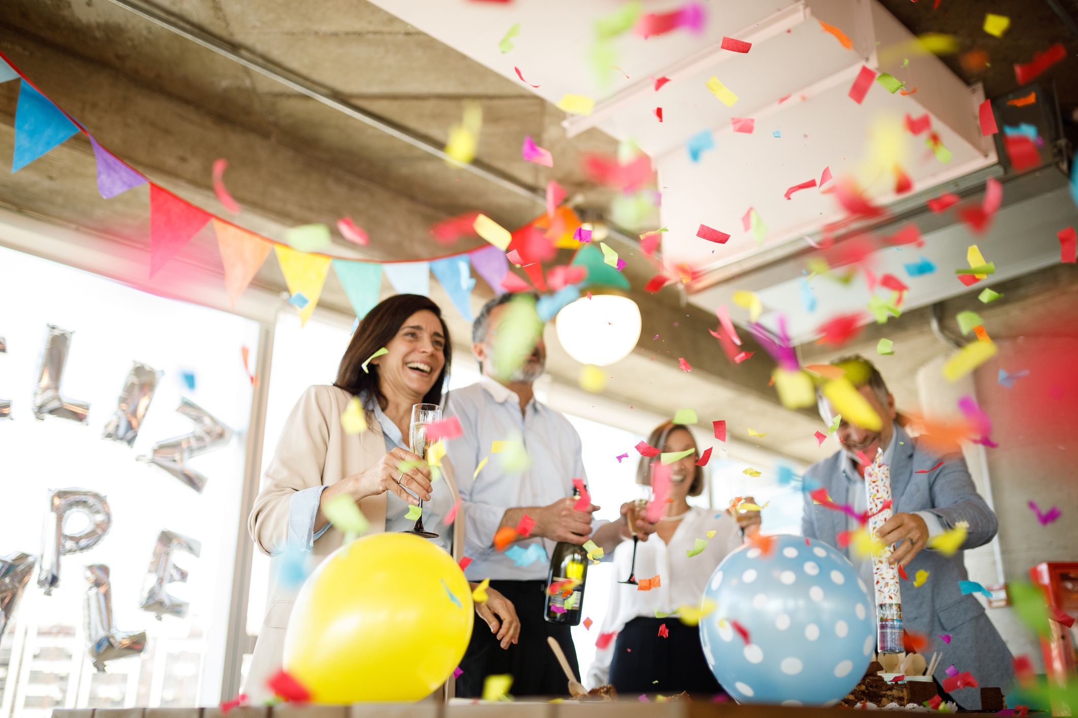 Coworkers celebrating birthday in office.