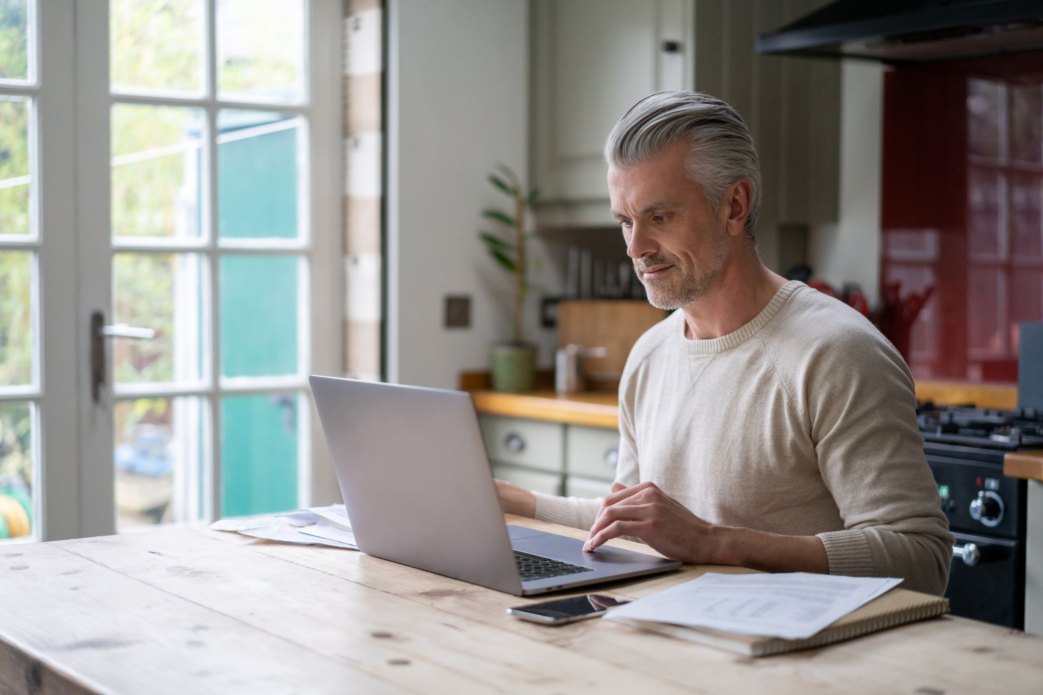 Portrait of an adult man working online at home on his laptop computer â lifestyle concepts