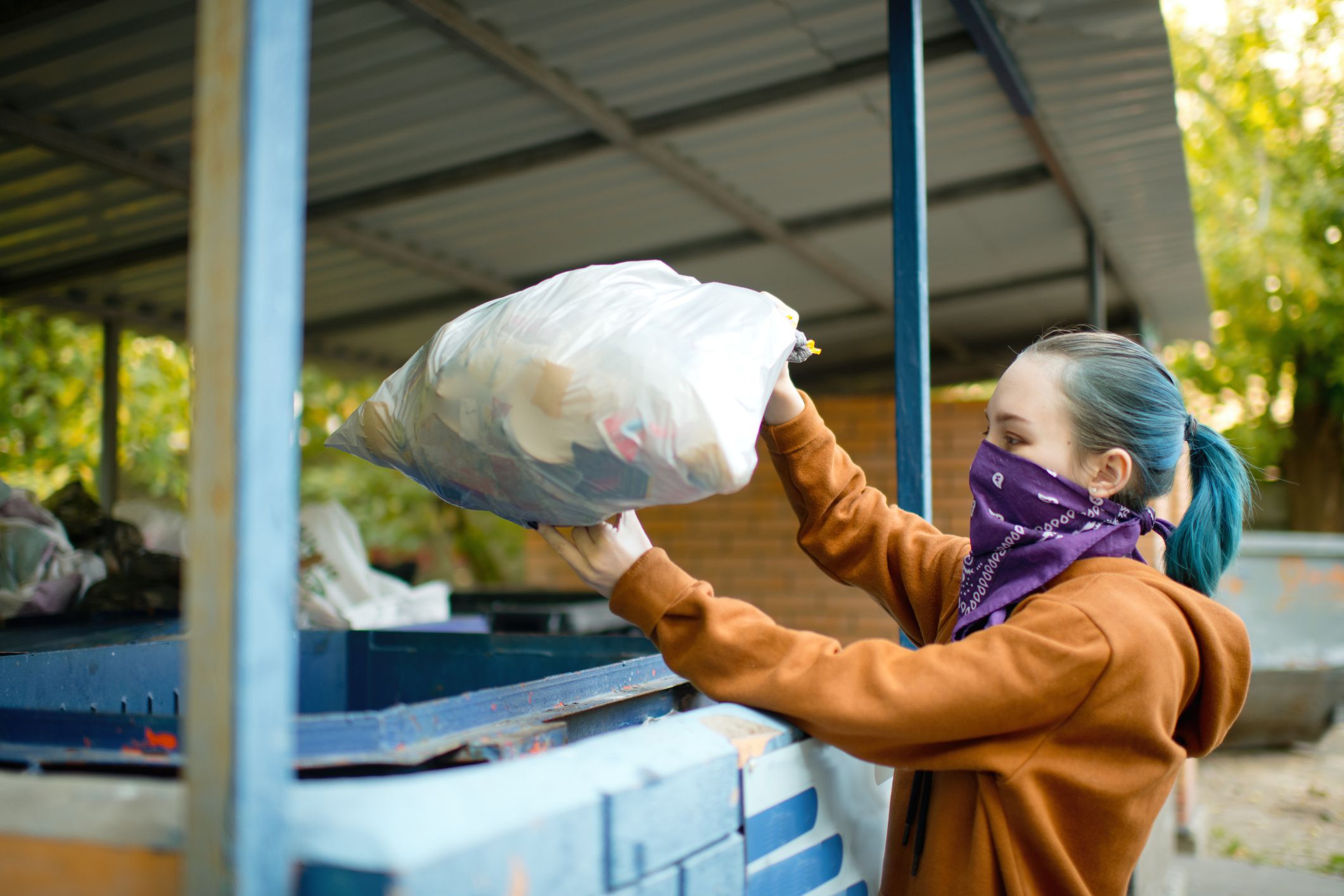 Teenage girl walking with garbage during COVID-19 pandemic