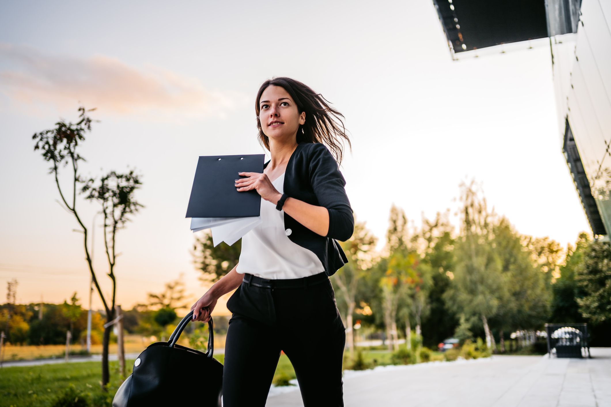 Beautiful young businesswoman running late in office.