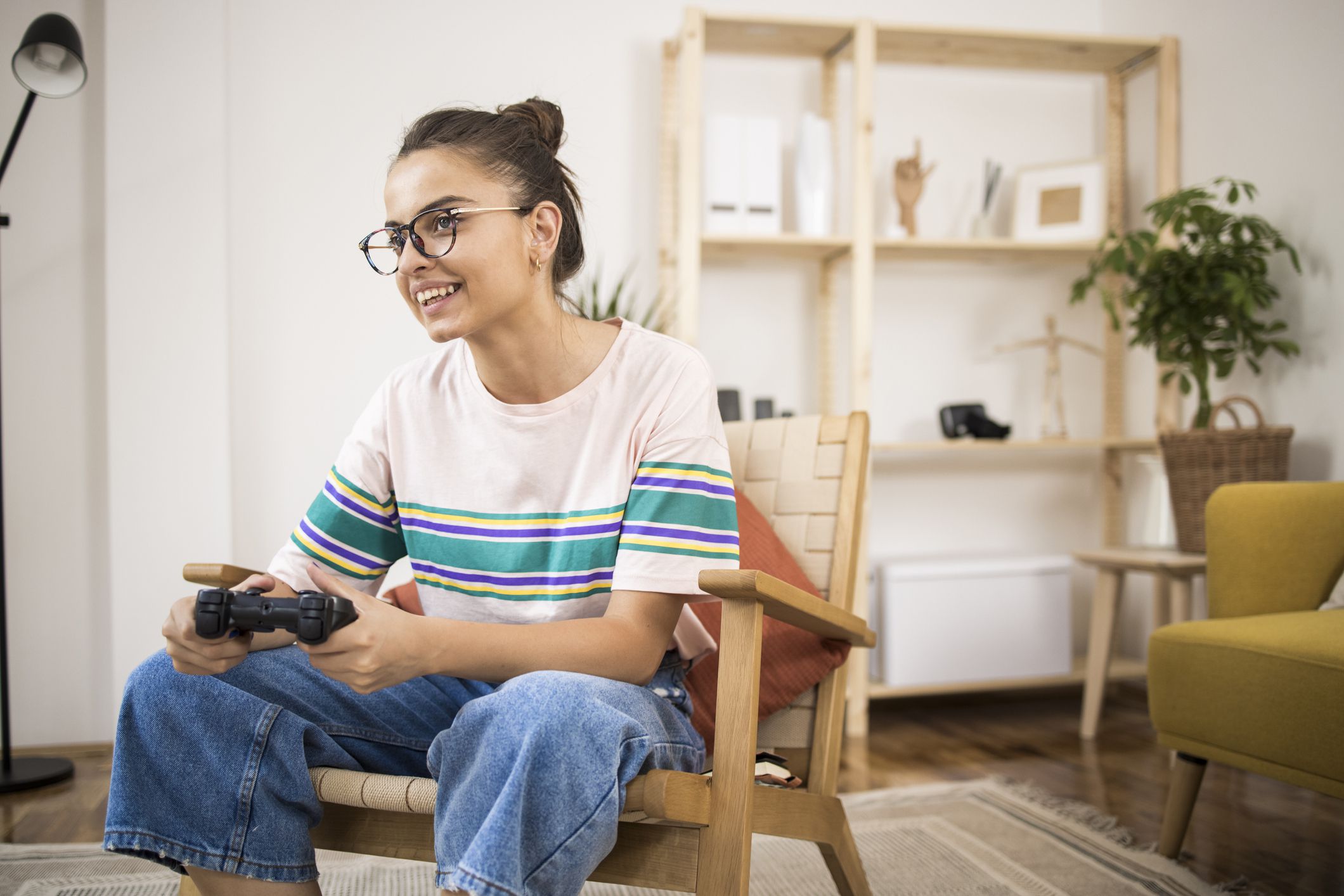 Portrait of a young woman playing video games at home and having fun.