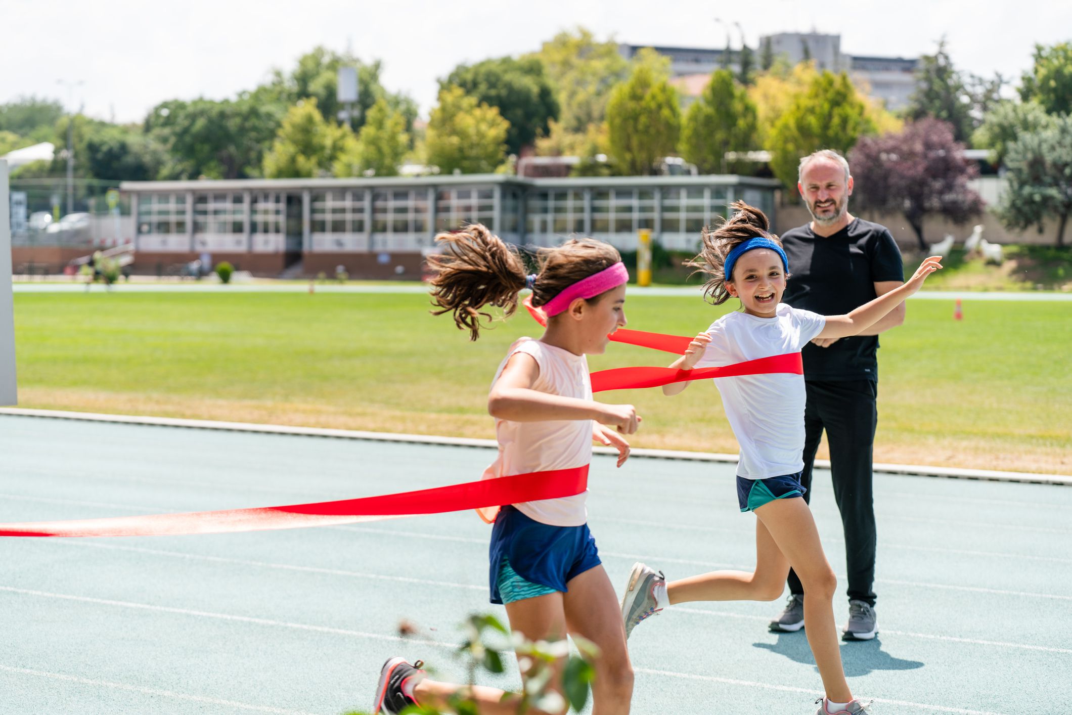little girls crossing the finish line of a track race