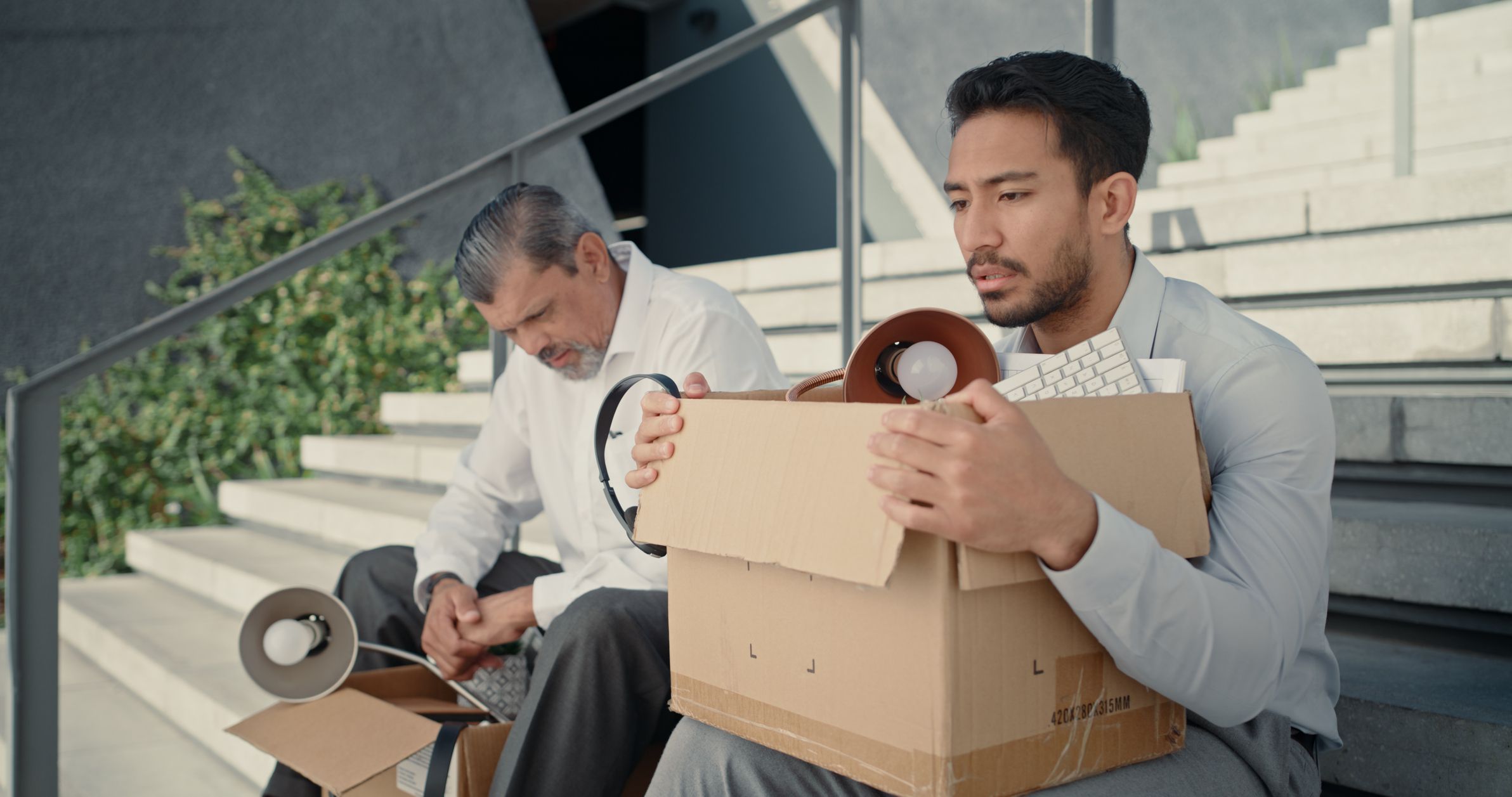 Box, fired and depression with business people on stairs for unemployed, stress and sad. Failure, recession and bankrupt with jobless man and cardboard for dismissed, mental health and frustrated