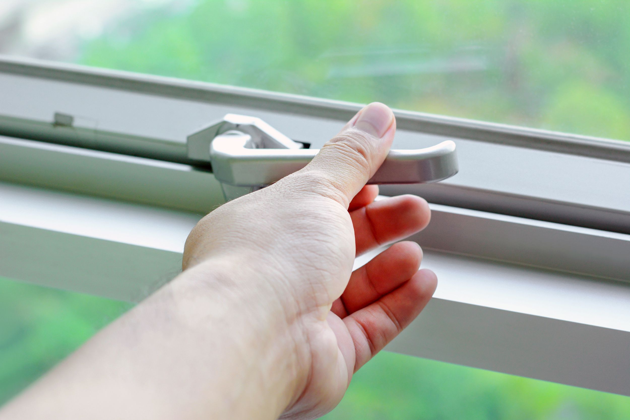 hand holding glass window latch lever