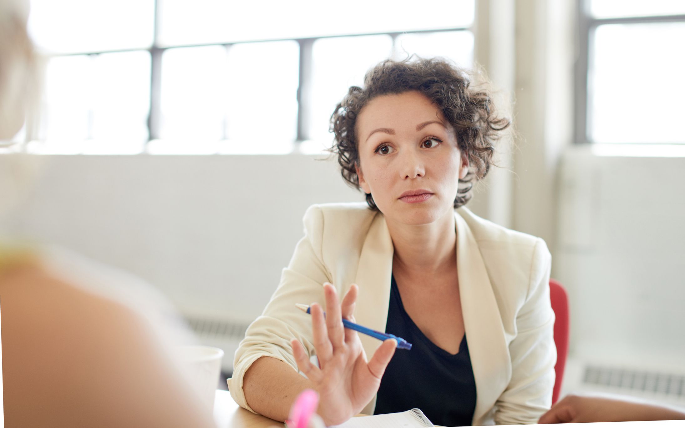 Candid picture of a female boss and business team collaborating. Filtered serie with light flares, bokeh, warm sunny tones.