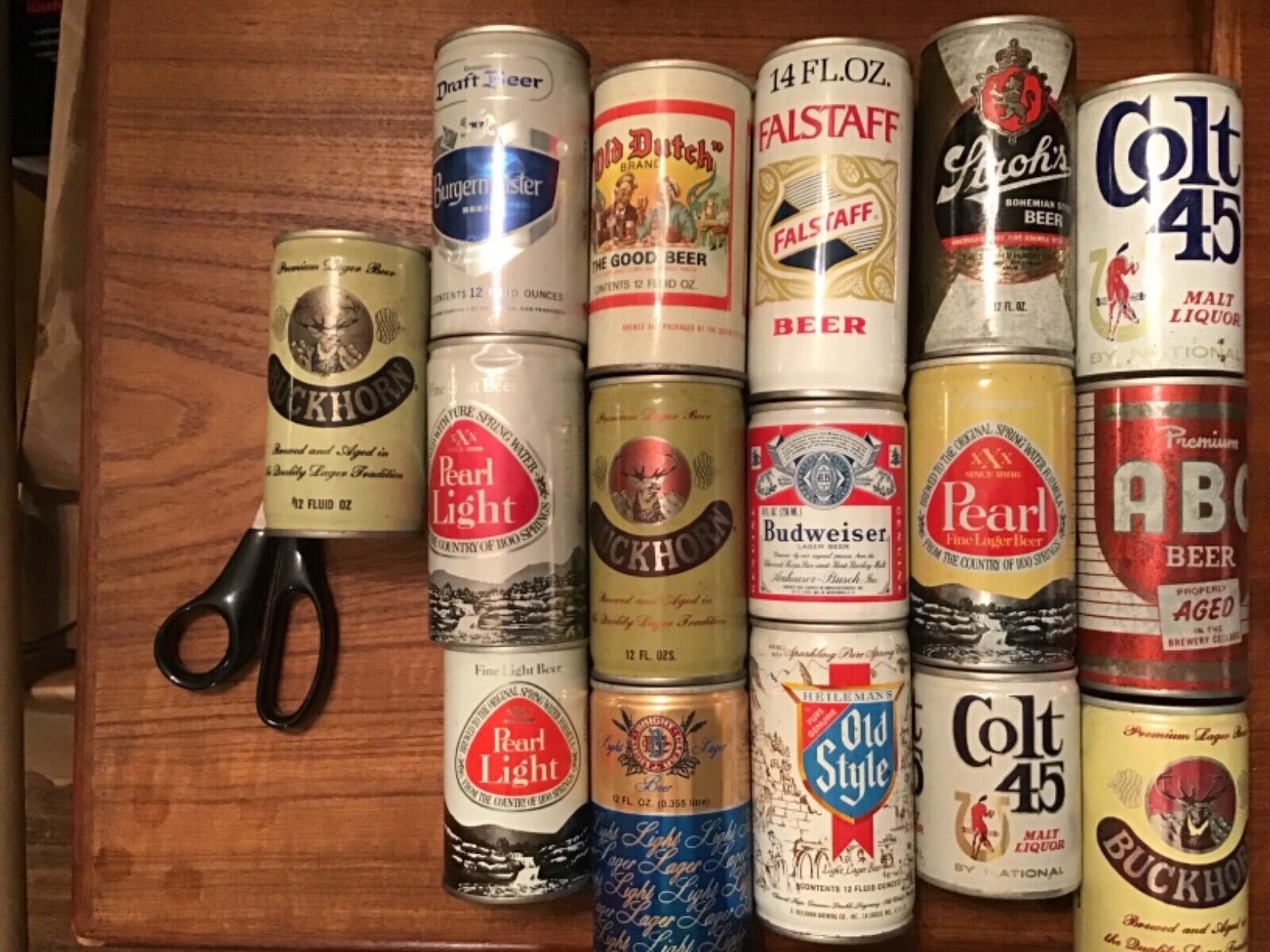 Vintage beer cans layed out on a table, the cans dating back to the 1980s