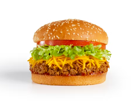 A sesame seed hamburger bun filled with shredded cheddar cheese, seasoned ground beef, shredded lettuce, tomato slices, and ketchup, all layered neatly on a white background.