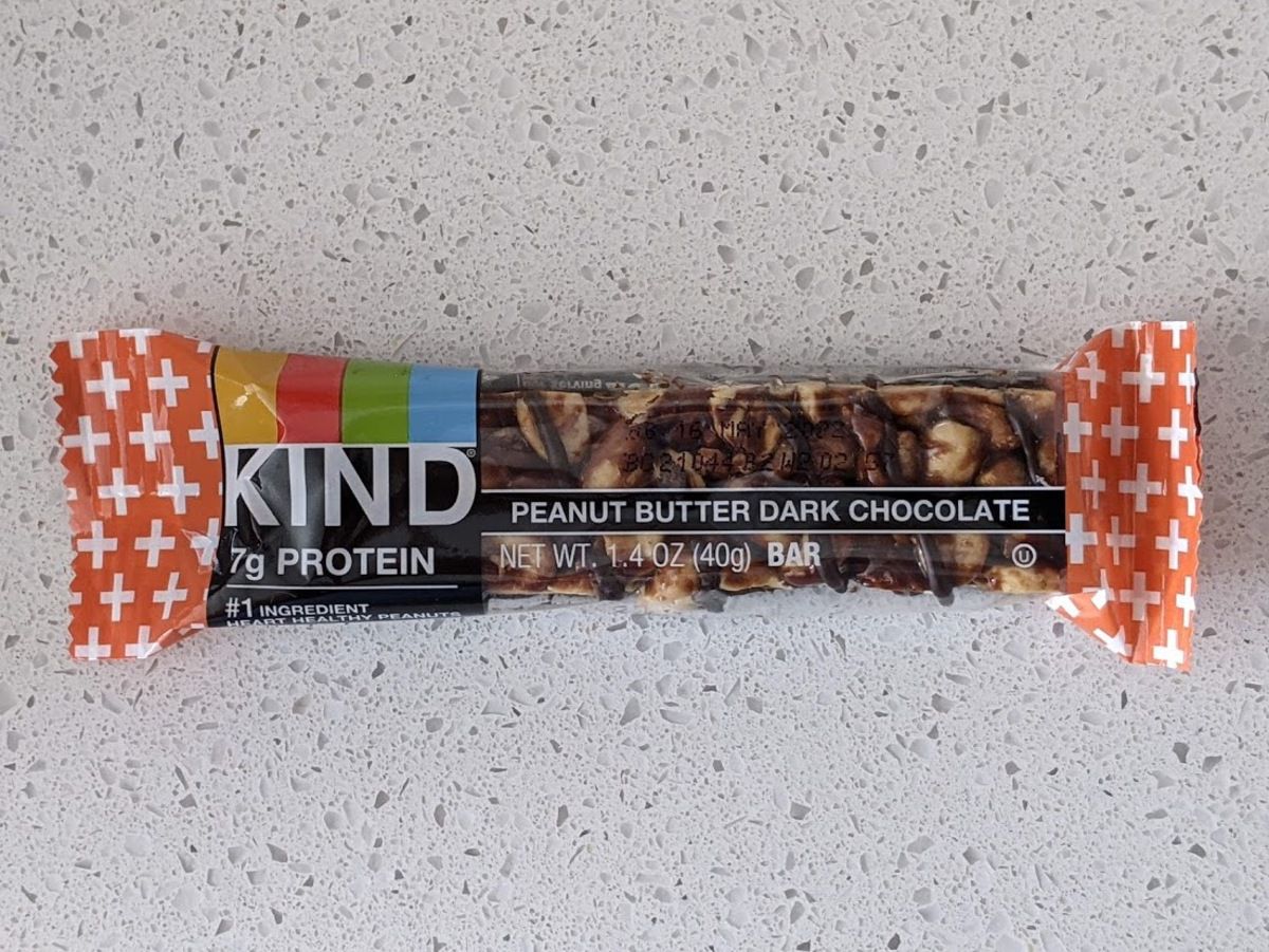 Kind Bar, Peanut Butter Dark Chocolate, on a light grey countertop with light grey tiles in the background