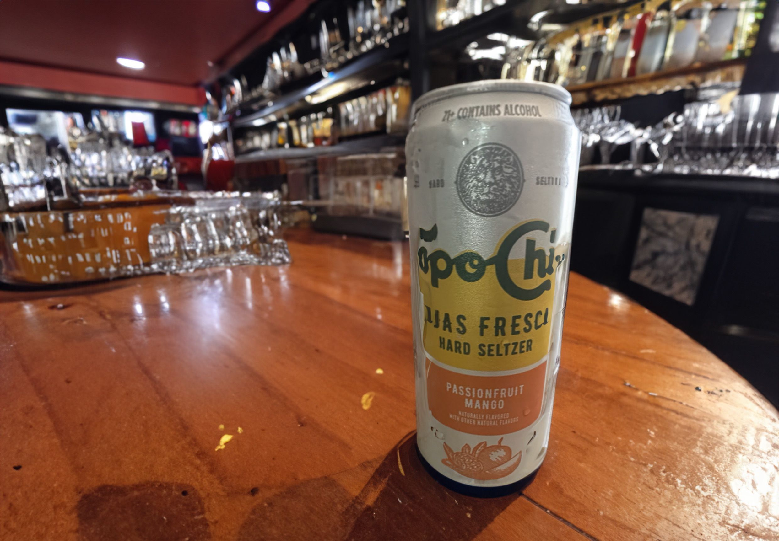 Passionfruit Mango Topo Chico Hard Seltzer can on a bar