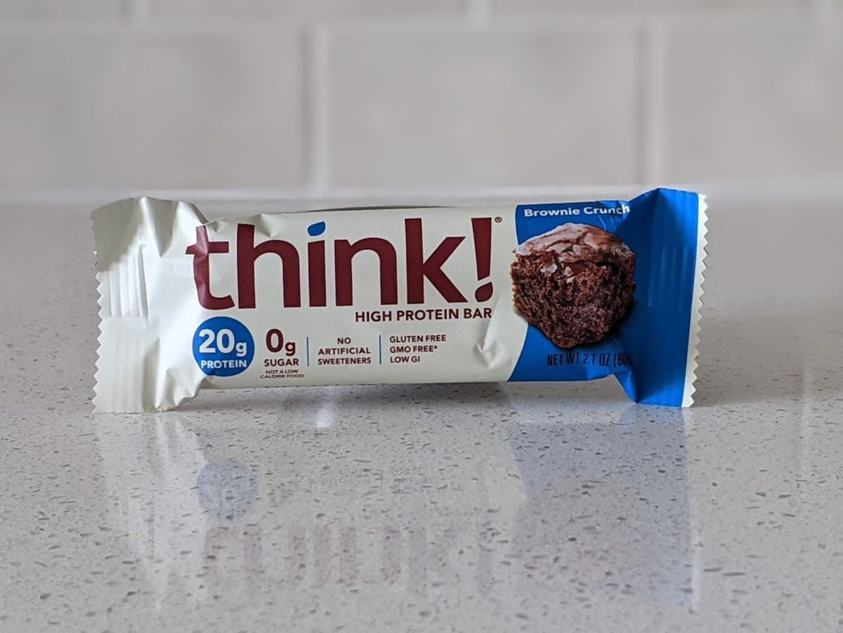 Think! High Protein Bar, Brownie Crunch, on a light grey countertop with light grey tiles in the background