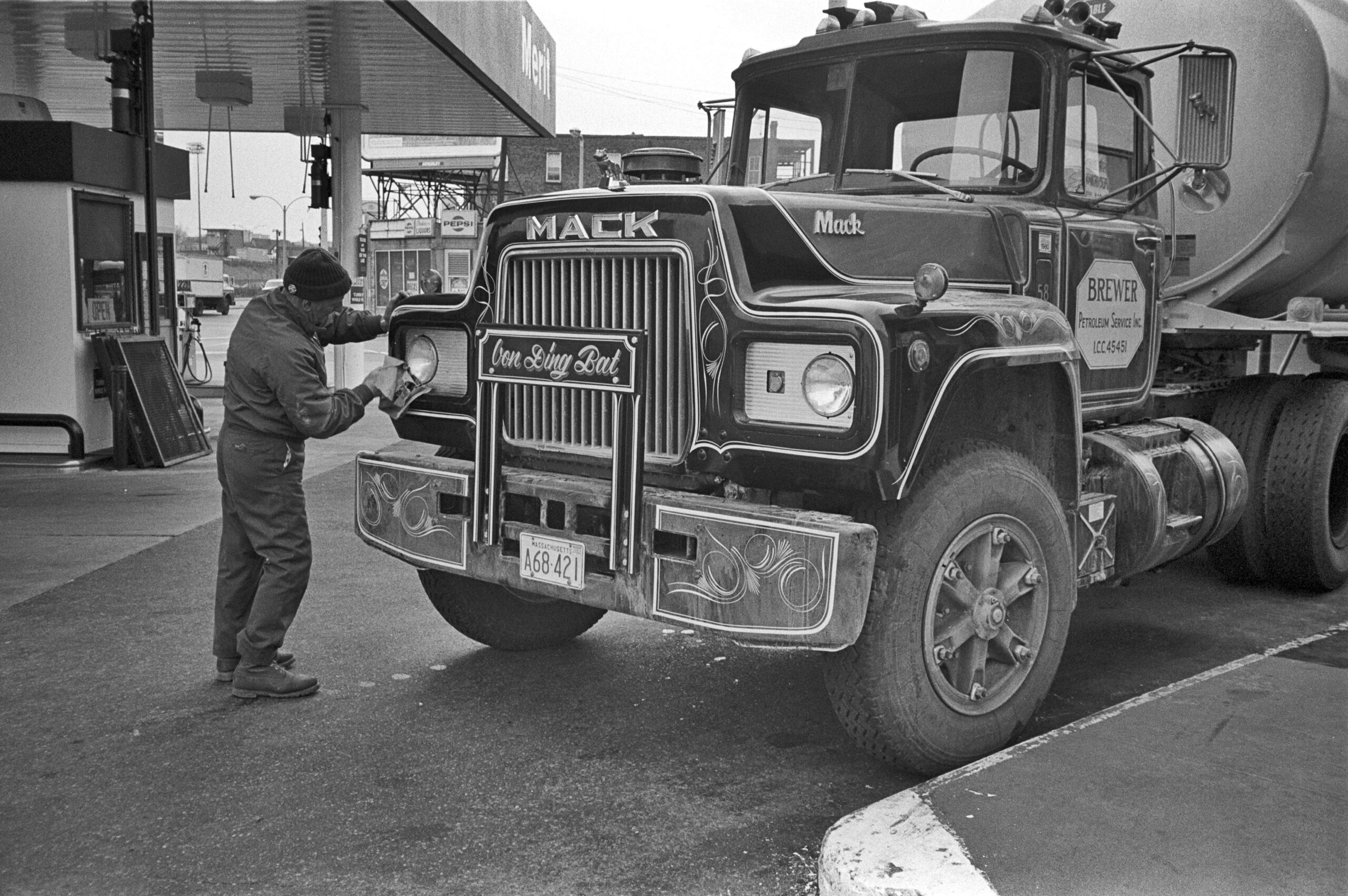 Truck Driver Cleans Headlights At Gas Station