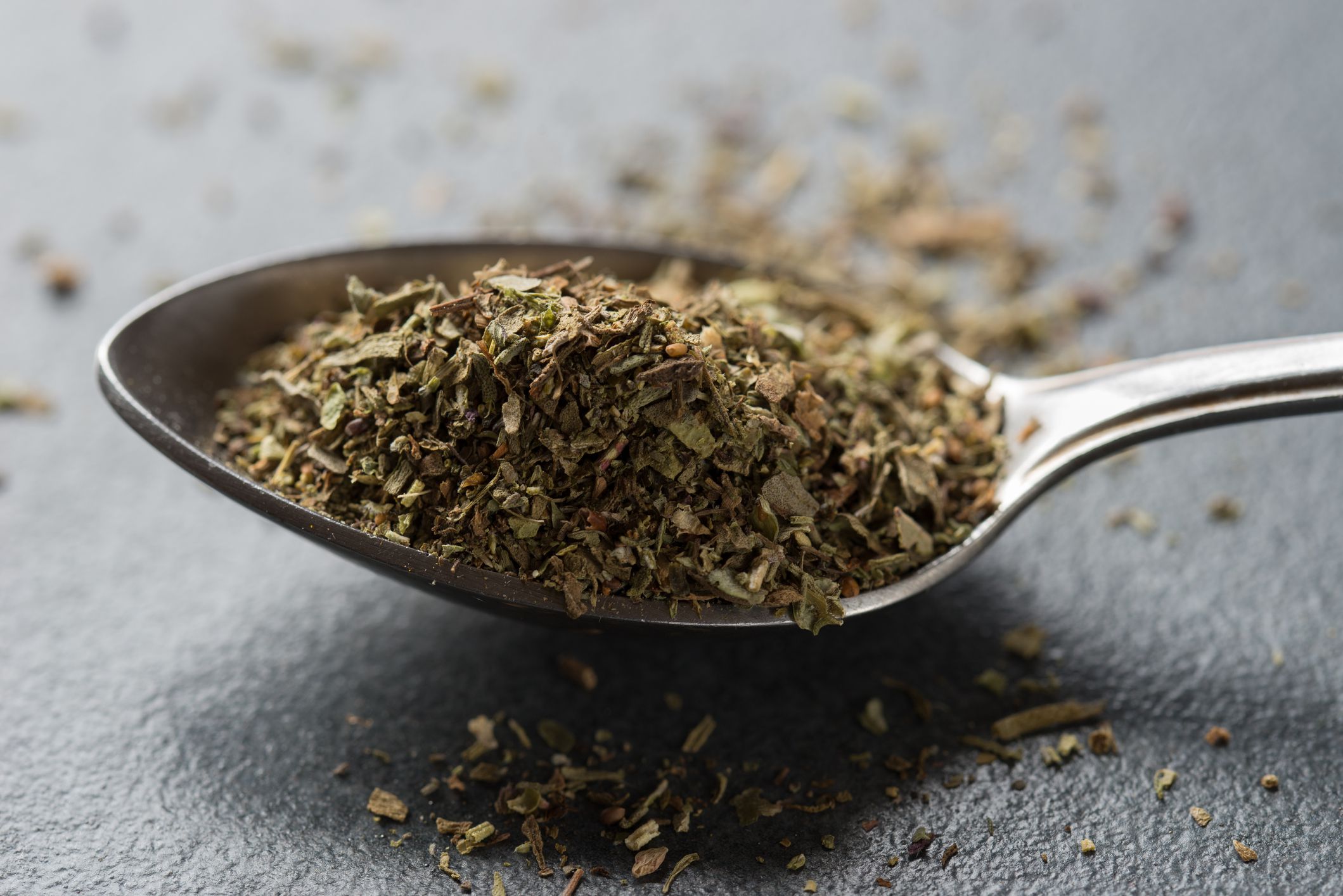 spoon of herbes de Provence on table macro