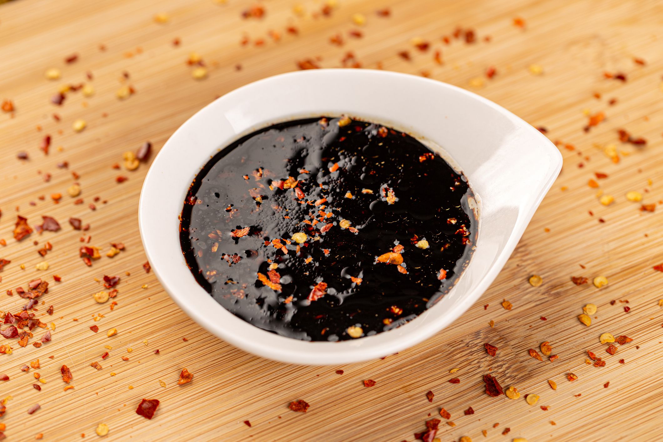 Bowl of teriyaki sauce, traditional Japanese sauce on bamboo board