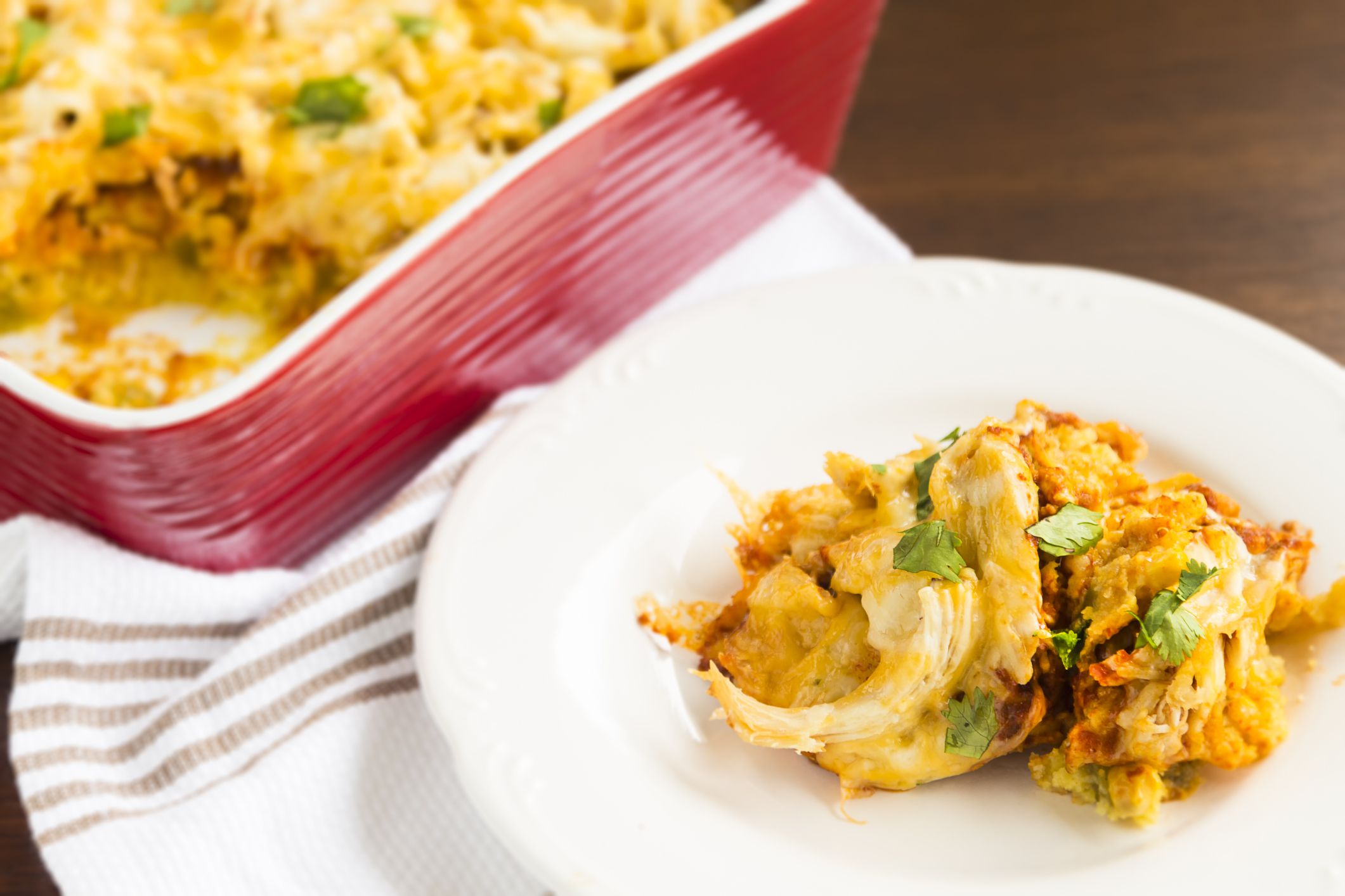 Delicious cheesy, spiced cornbread topped with enchilada sauce, shredded chicken, cheese and cilantro