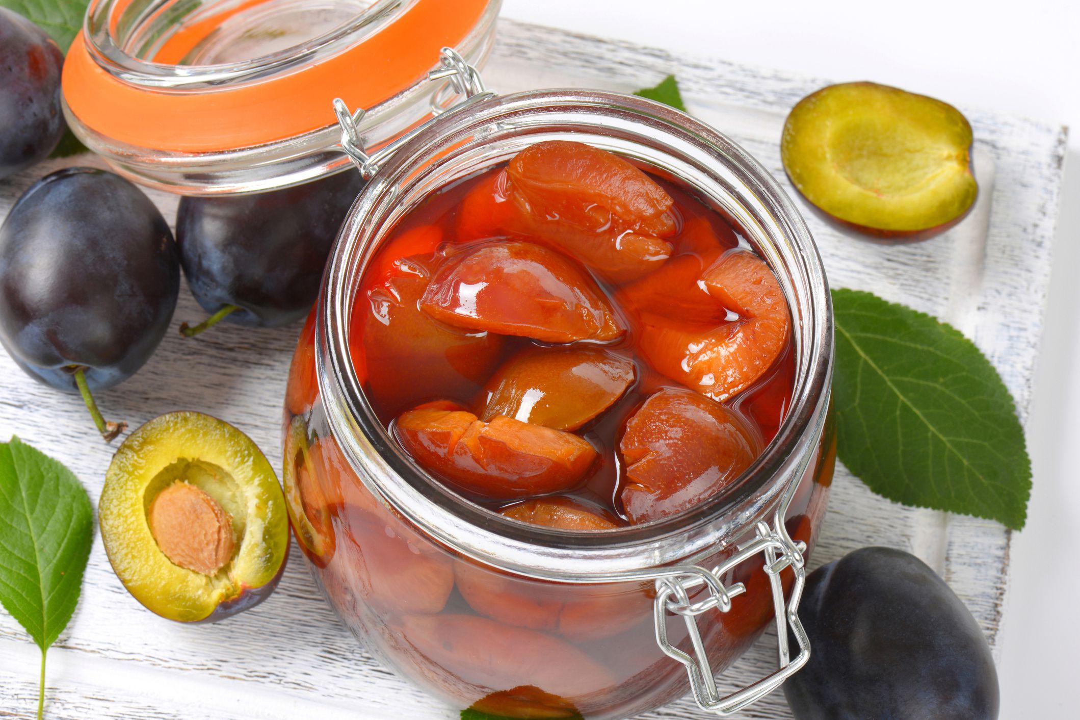pickled plums in jar, plums in foreground