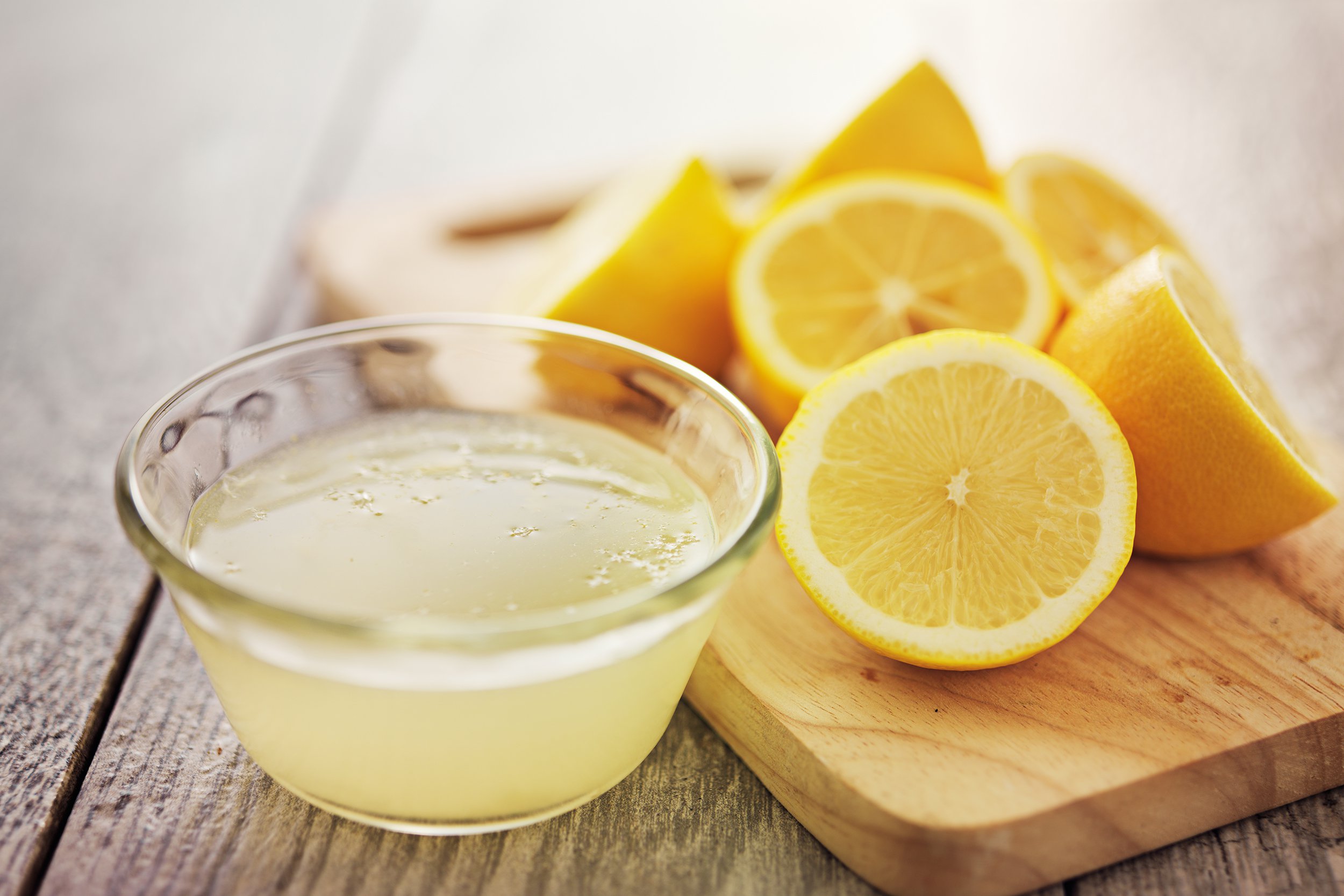 lemon juice with lemons in background