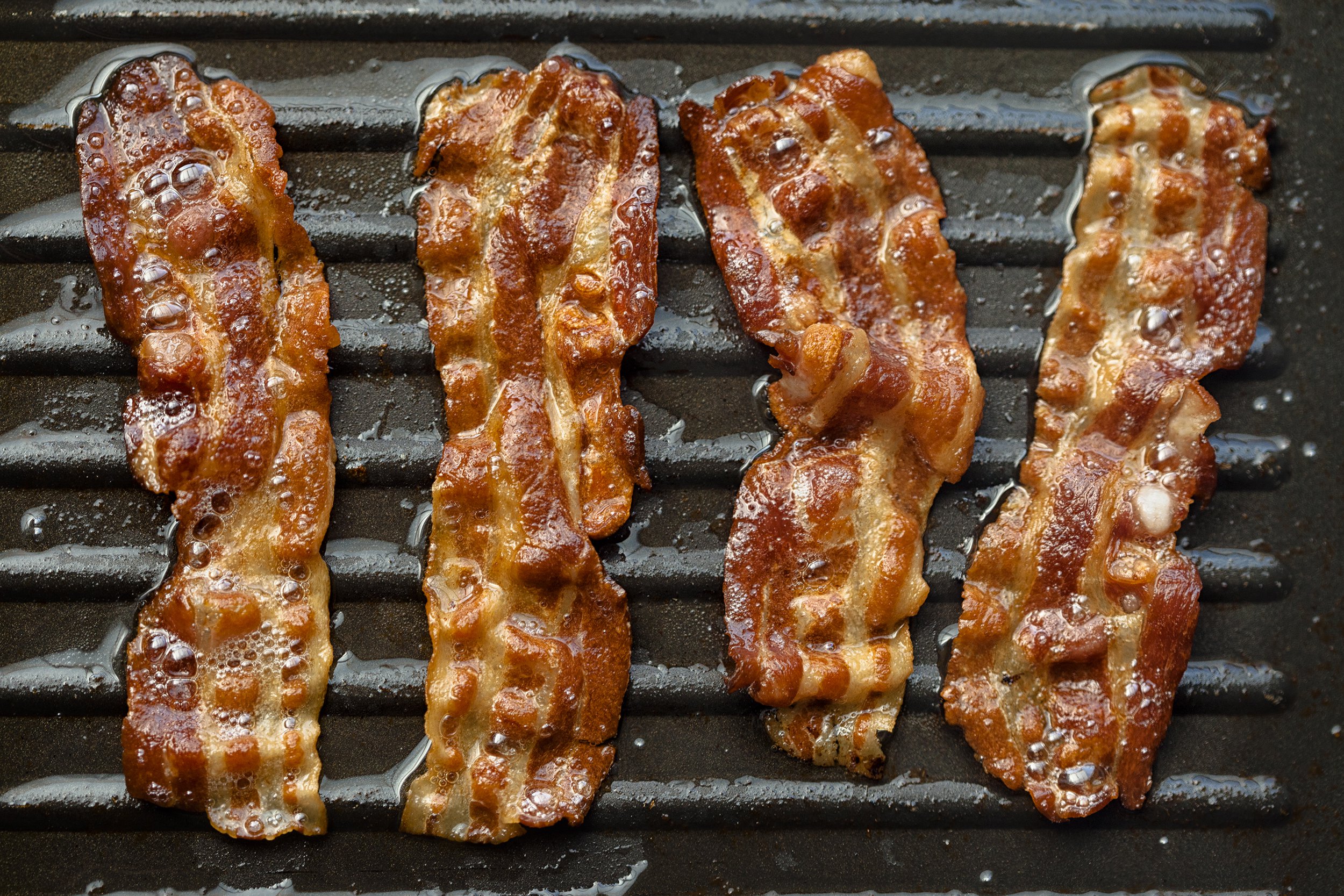 bacon frying on the grill