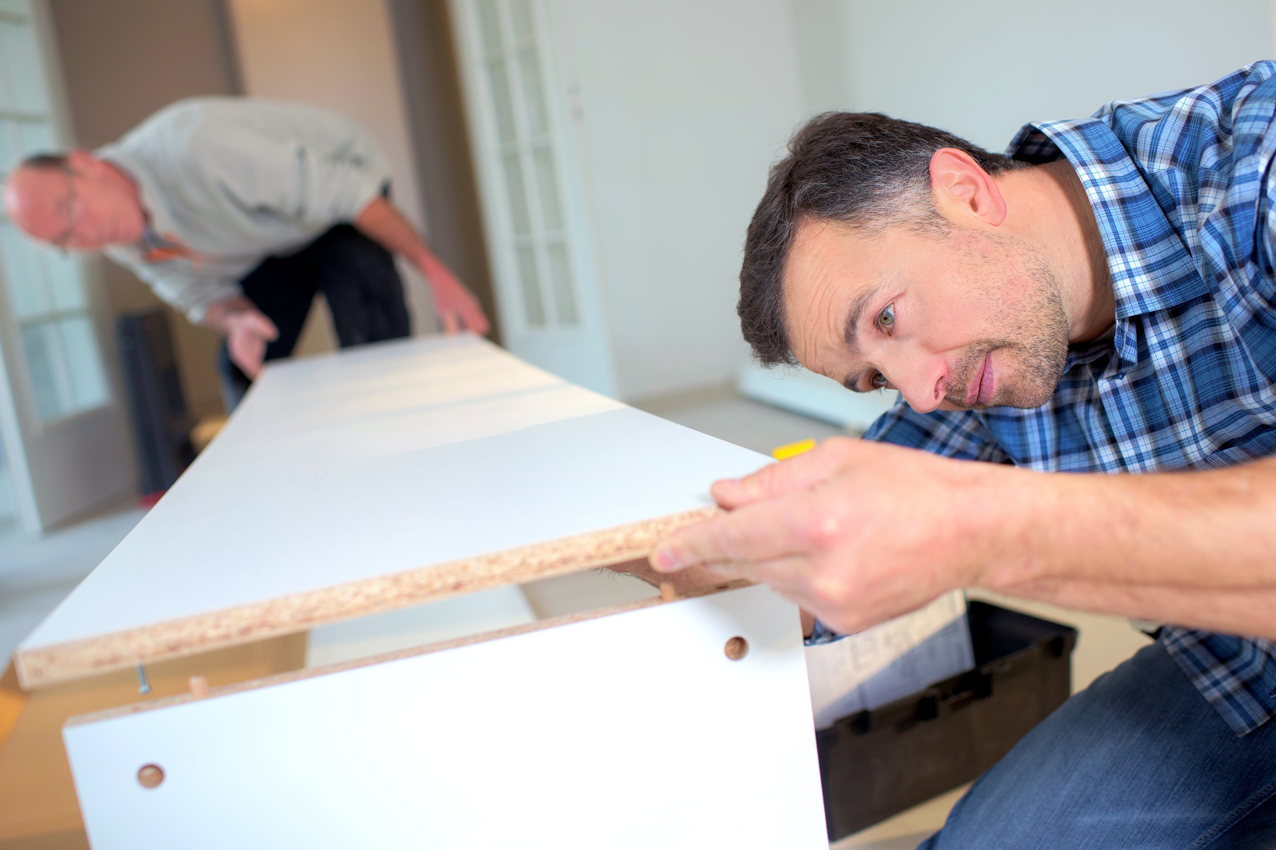 two men putting together flap pack furniture