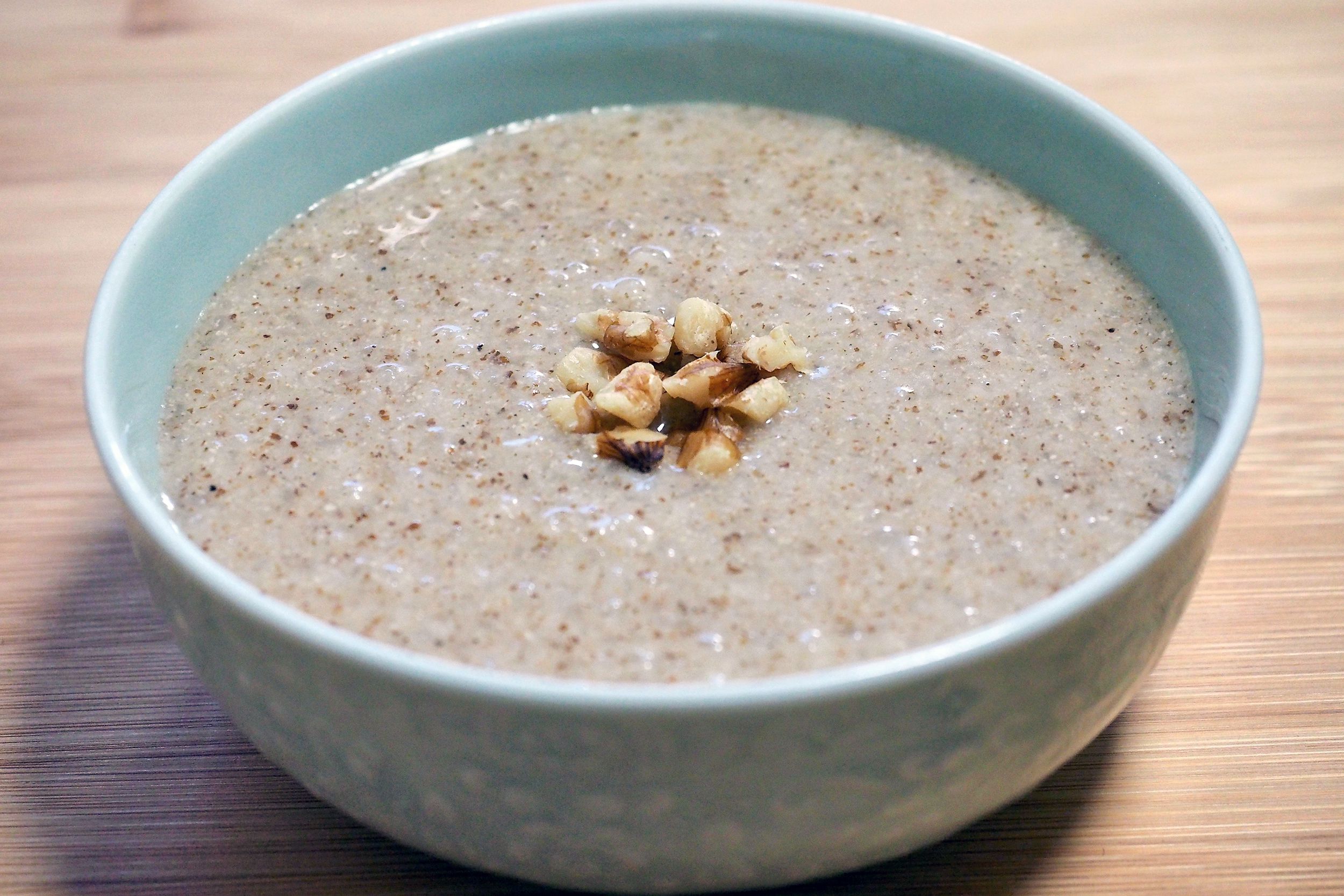 Closeup of cinnamon cream of wheat in a blue bowl on a wooden table