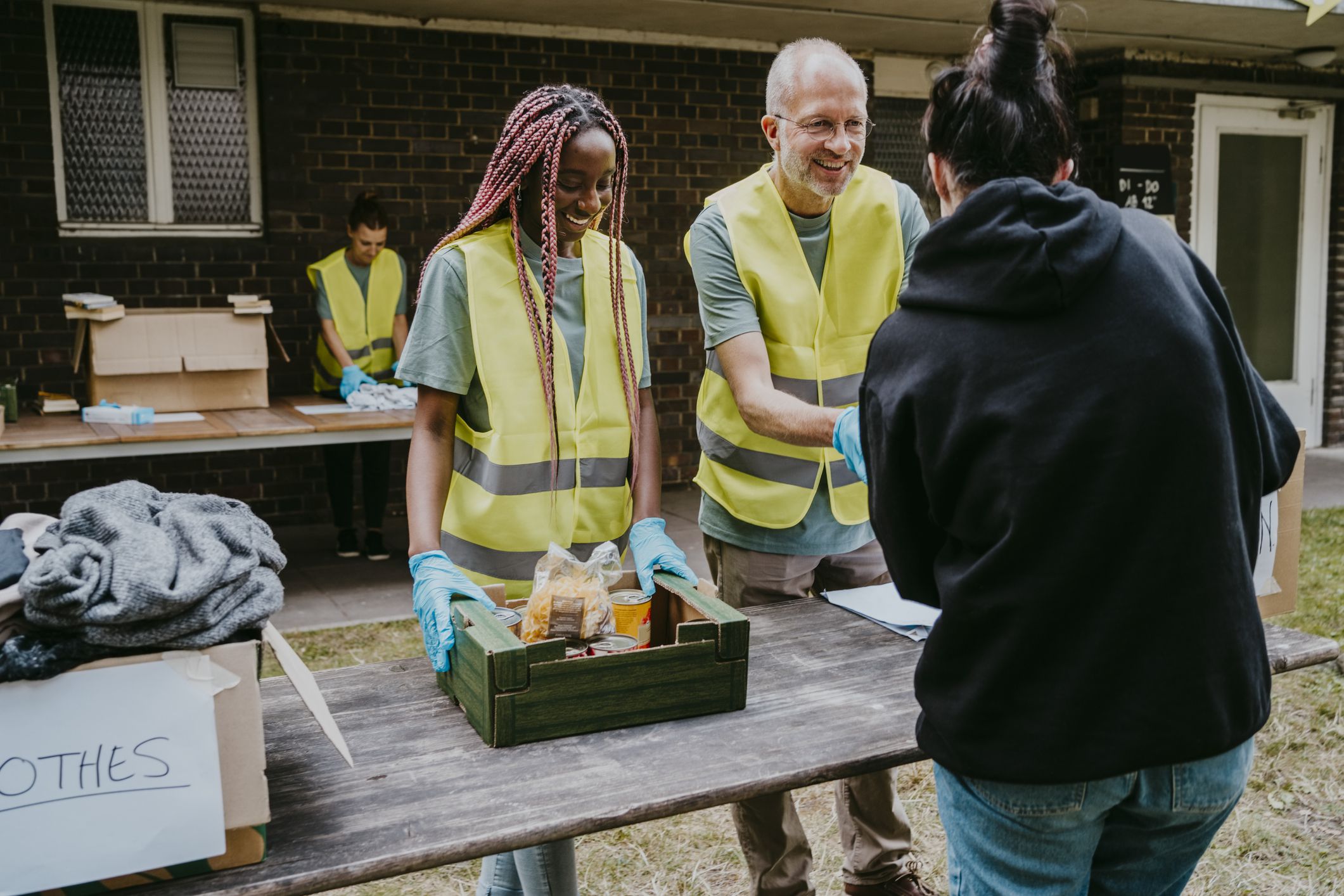 Smiling mature male volunteer giving food to woman