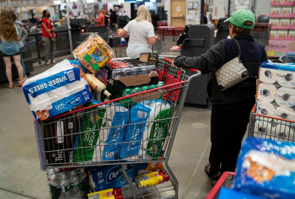 A shopper with a full cart waits to check out at a Costco