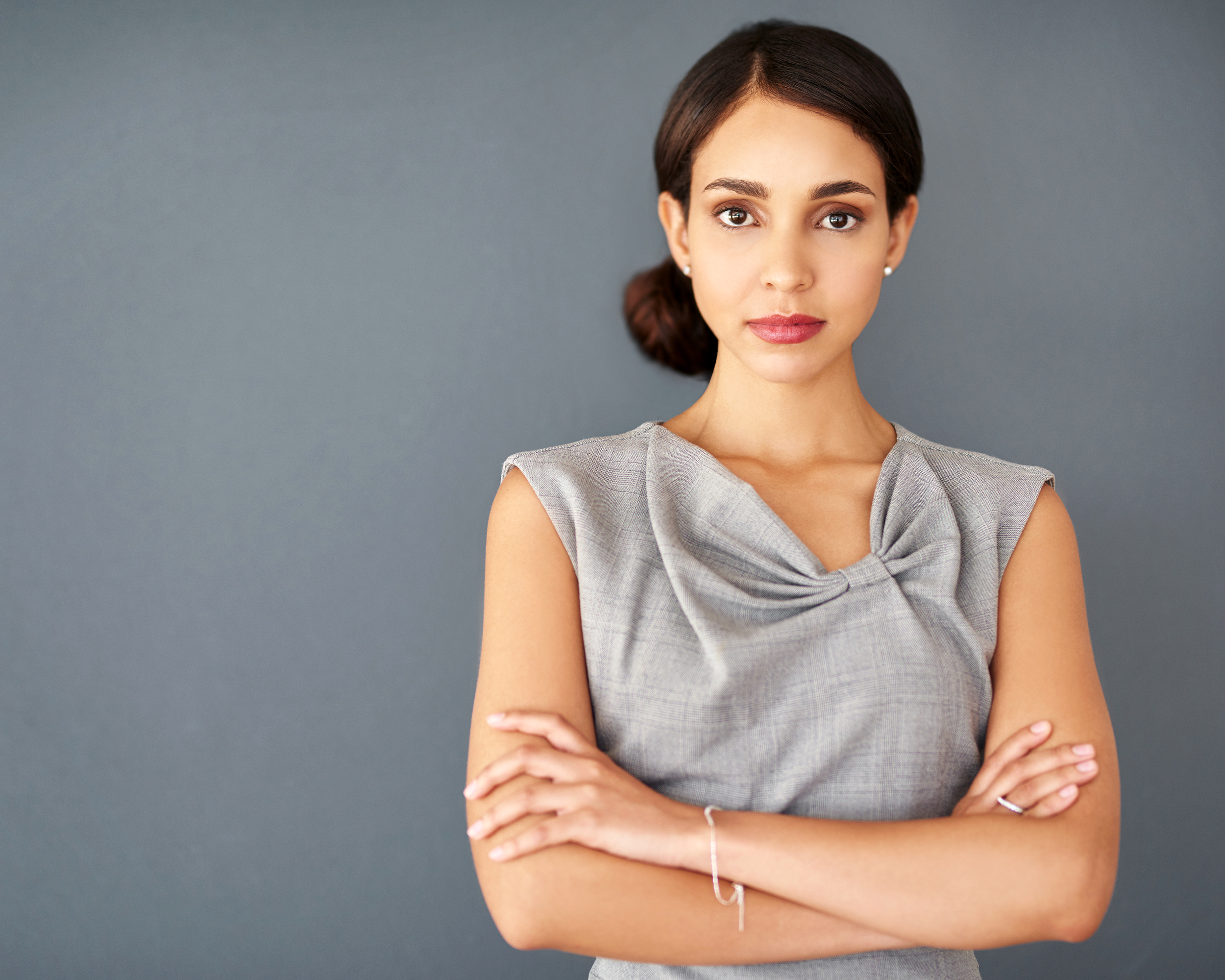 Female employee standing with arms folded