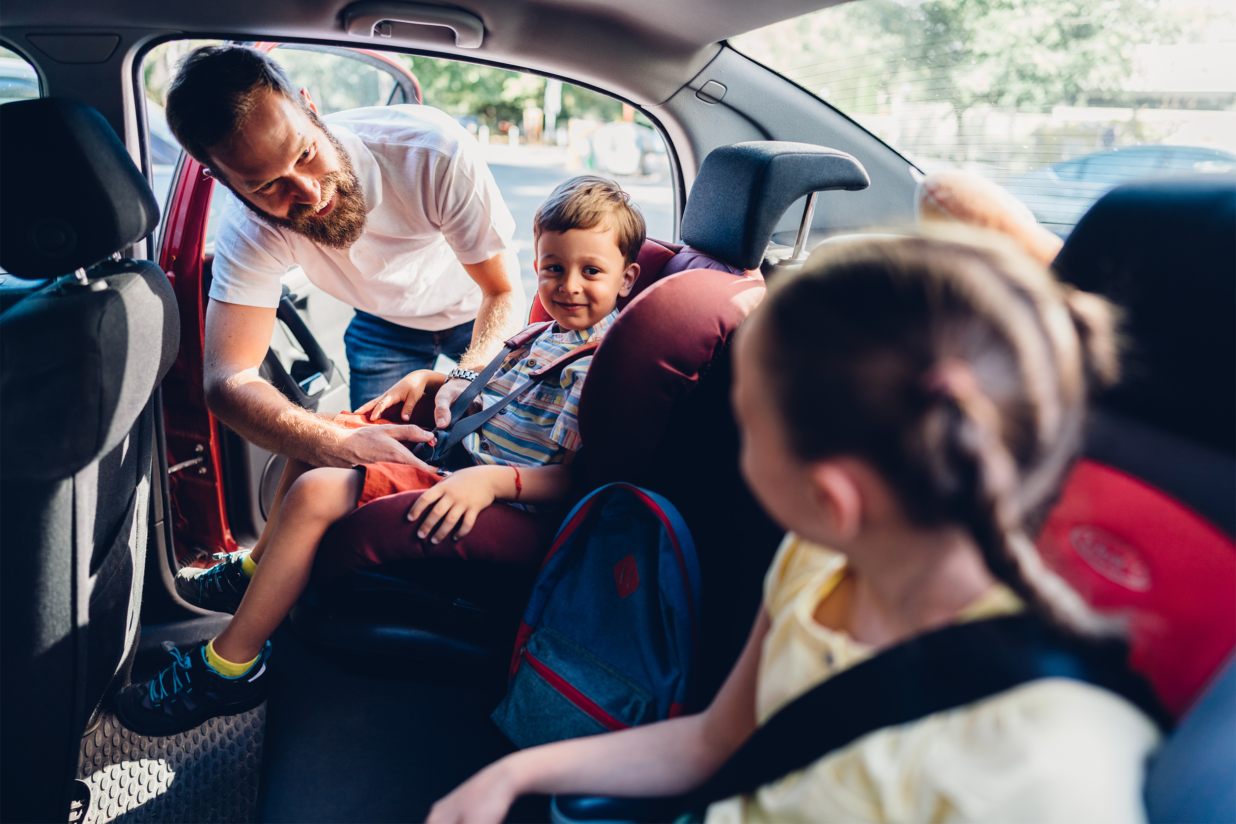 dad putting kids in car