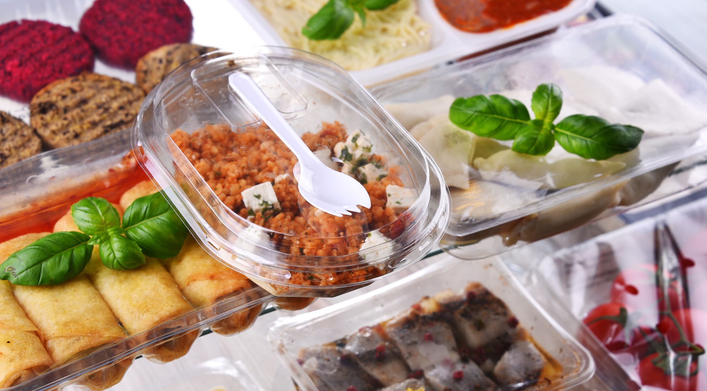 A variety of prepackaged food products in plastic boxes.