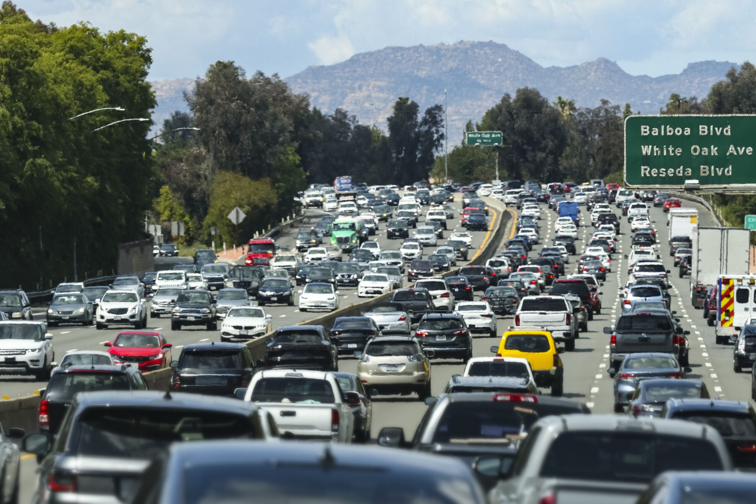 Traffic and street signs on an LA freeway.