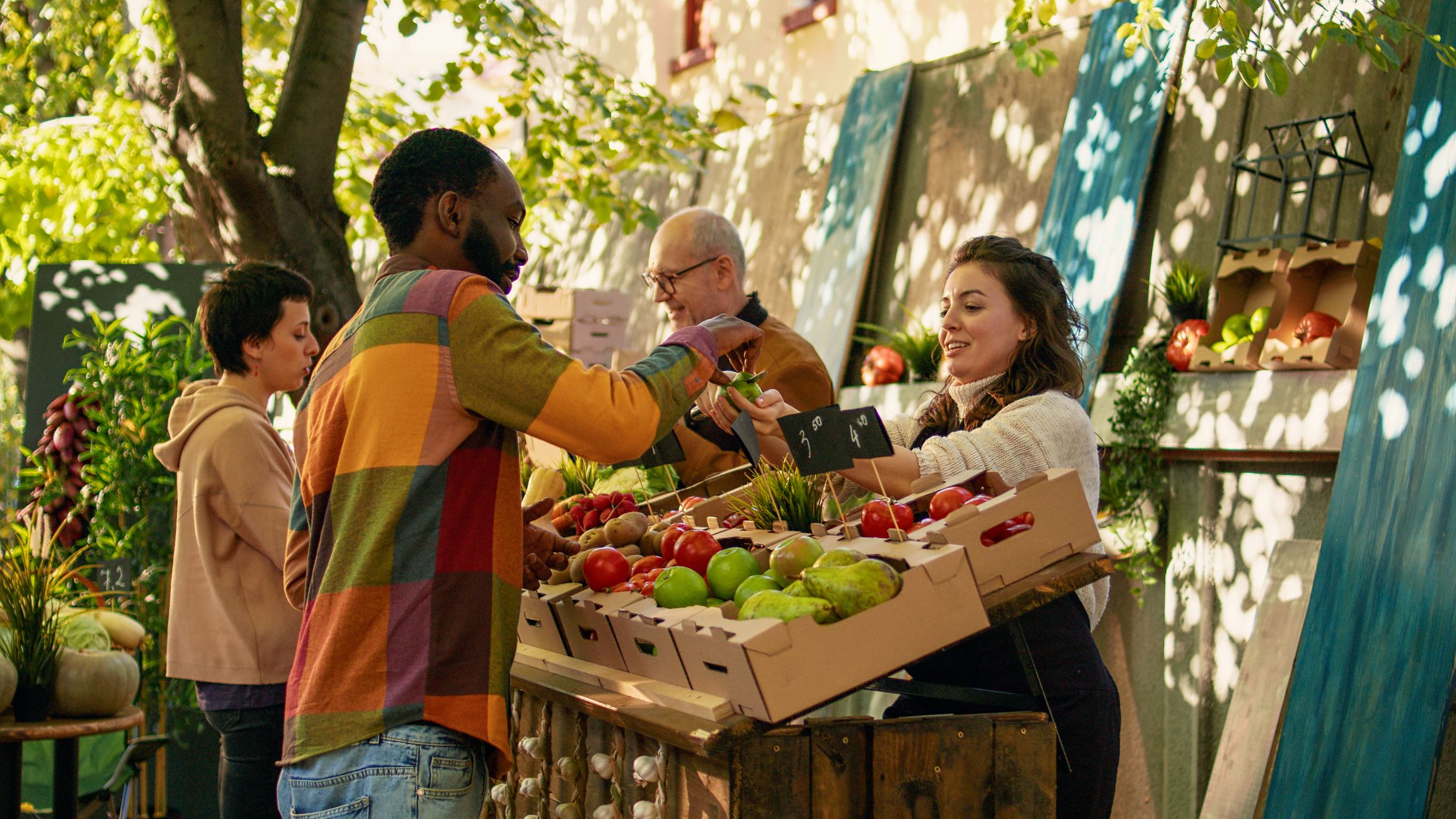 Female farmer giving free apple samples to clients for food tasting, enjoying bio products sampling at local greenmarket. Woman cutting slices of fruits to give to customers, business owner.