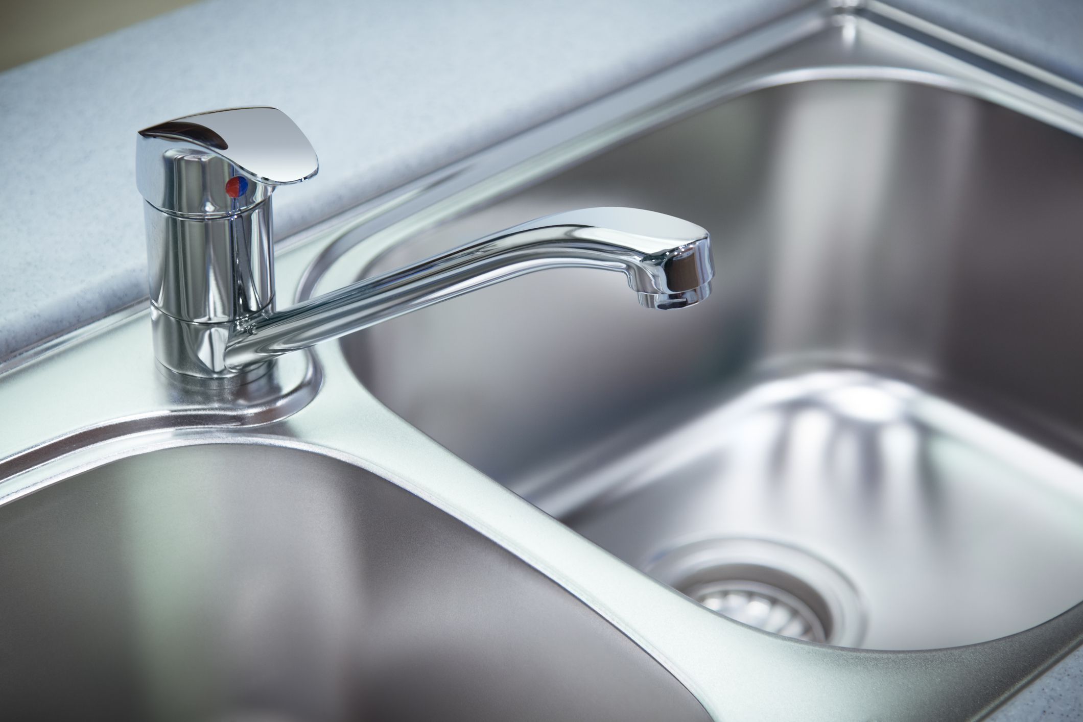 Close up shot for the clean chrome tap and washbasin in a kitchen