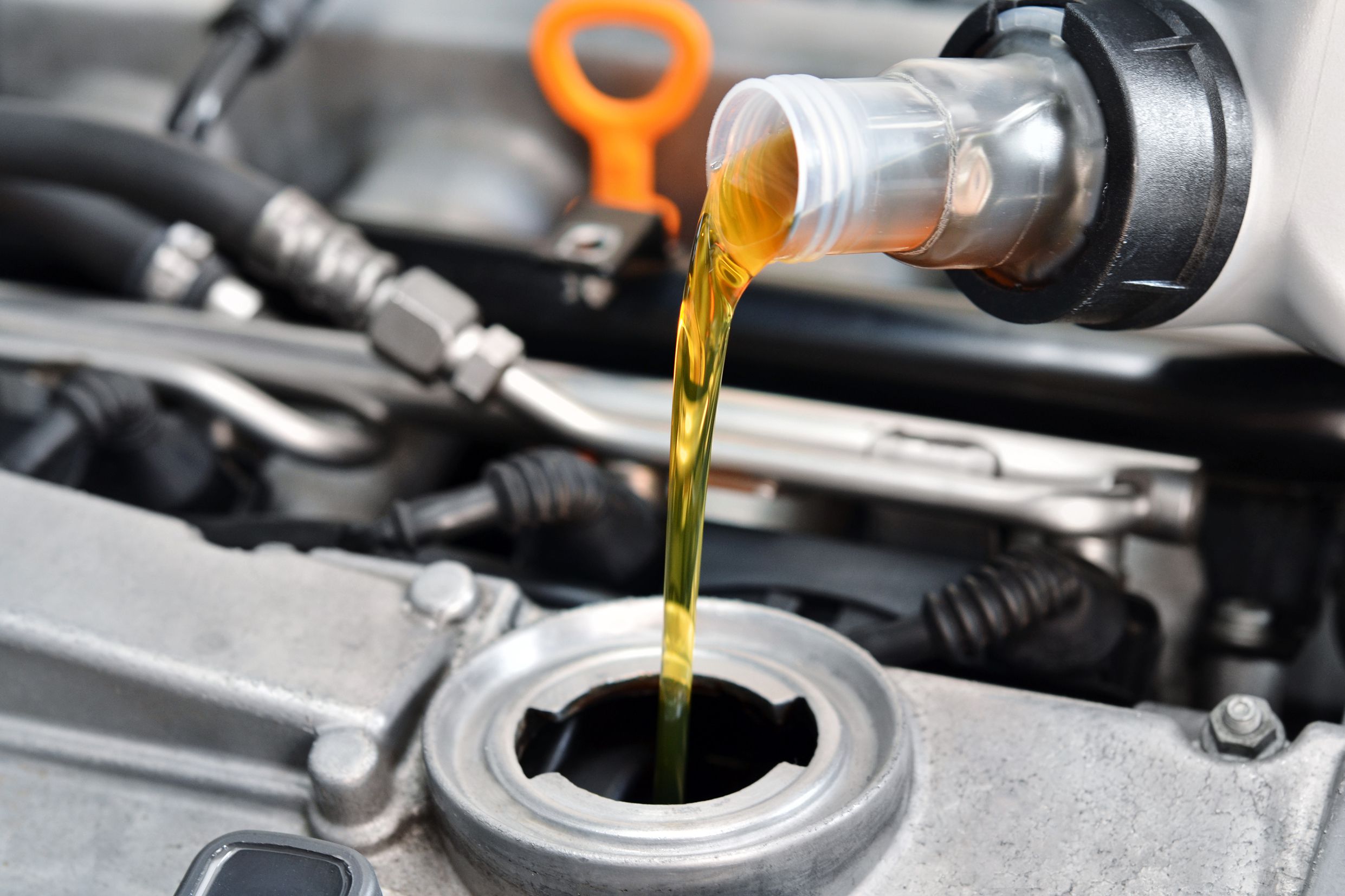 mechanic putting in fresh motor oil