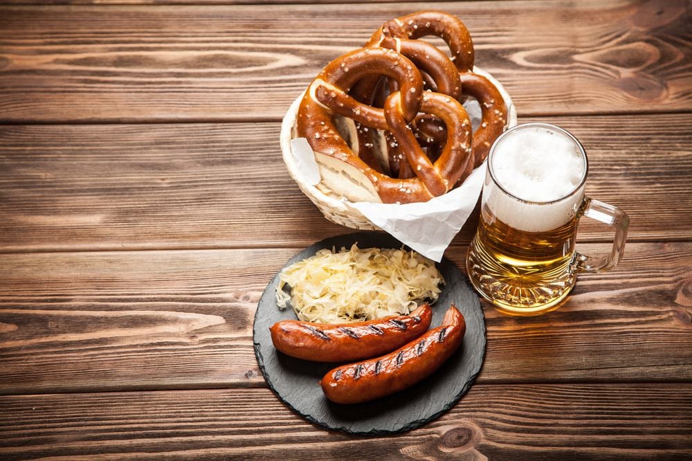 Pretzels, bratwurst and sauerkraut on wooden table