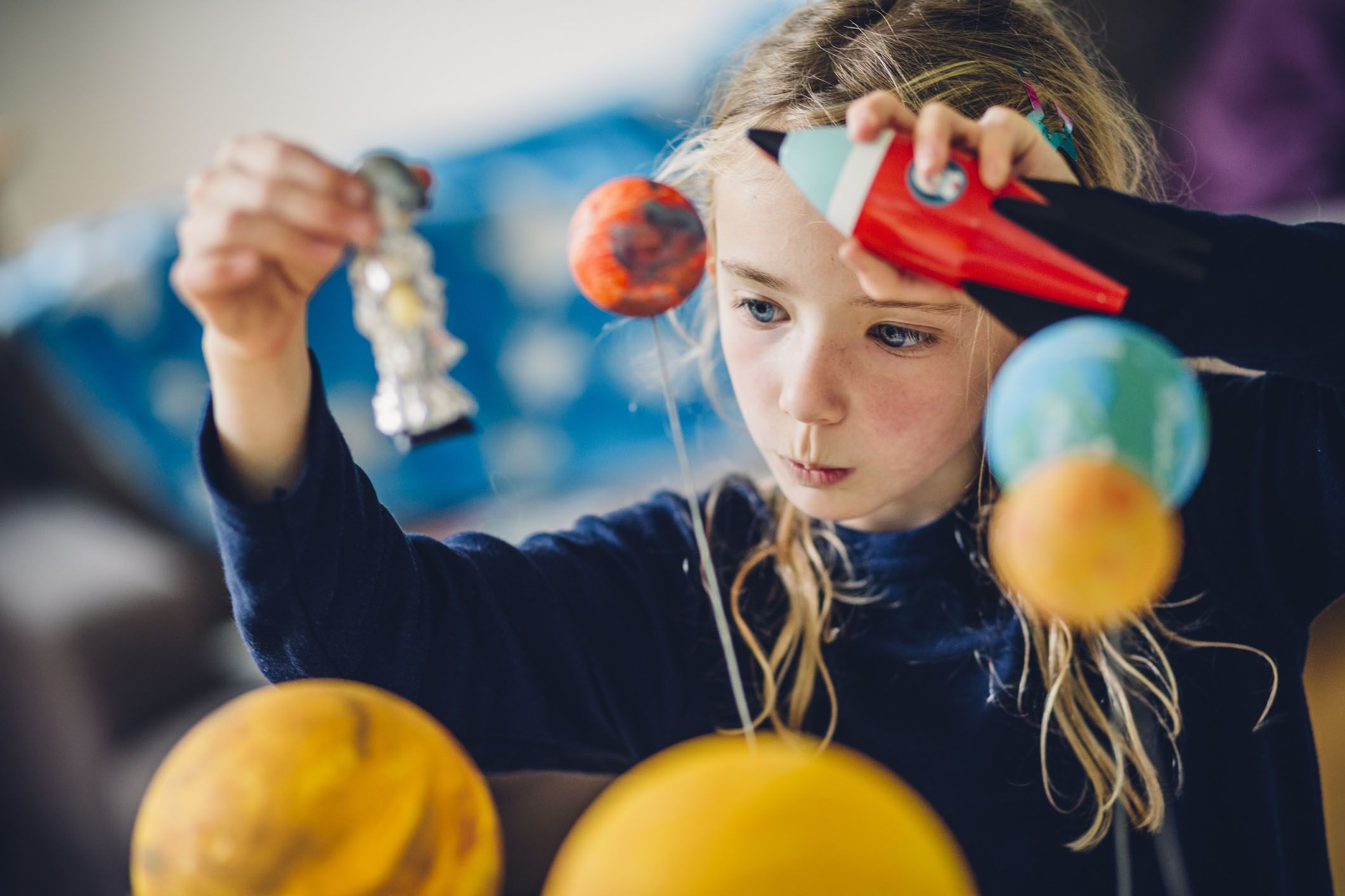 chihld playing with solar system model