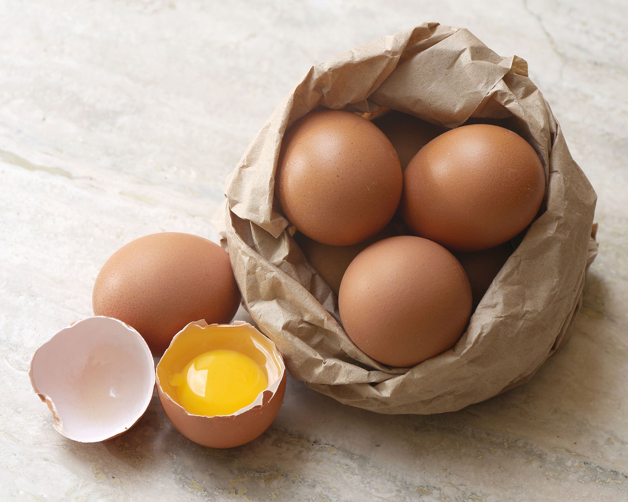 eggs in a brown bag, one opened on countertop