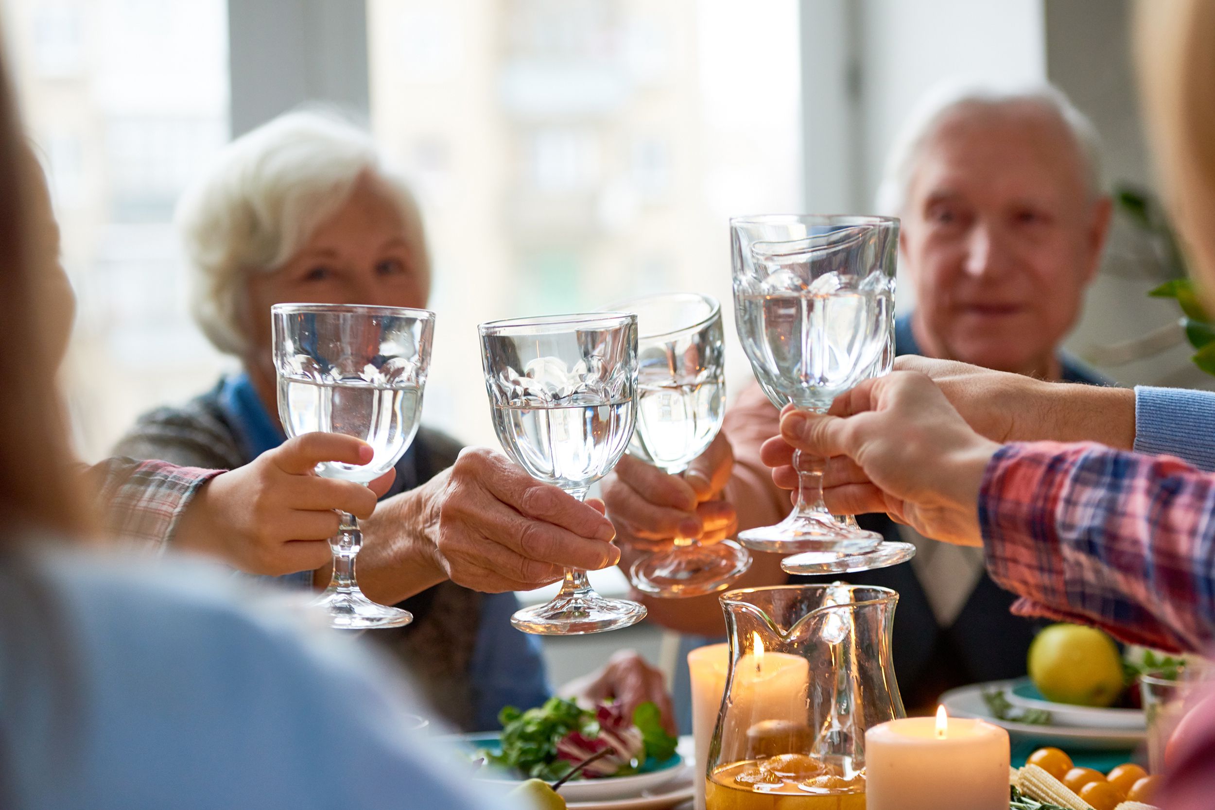 group of people eating dinner toasting glasses of water