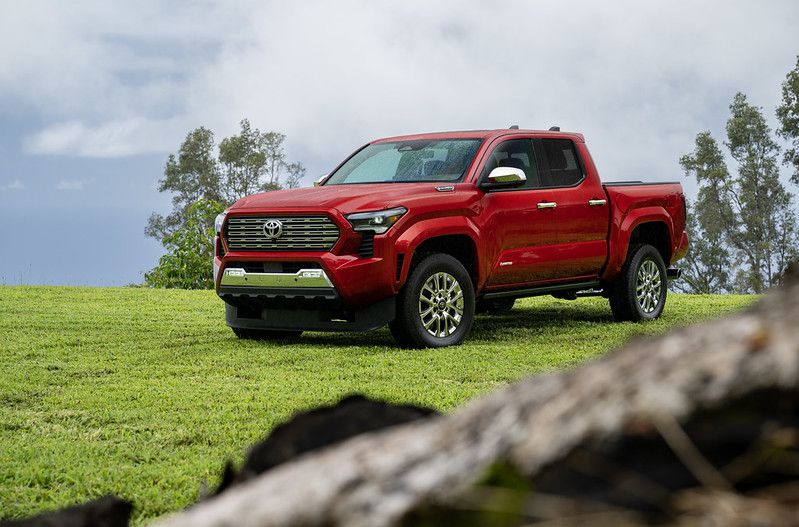 An image of a 2024 Toyota Tacoma parked on a grass field in Kona, Hawaii.
