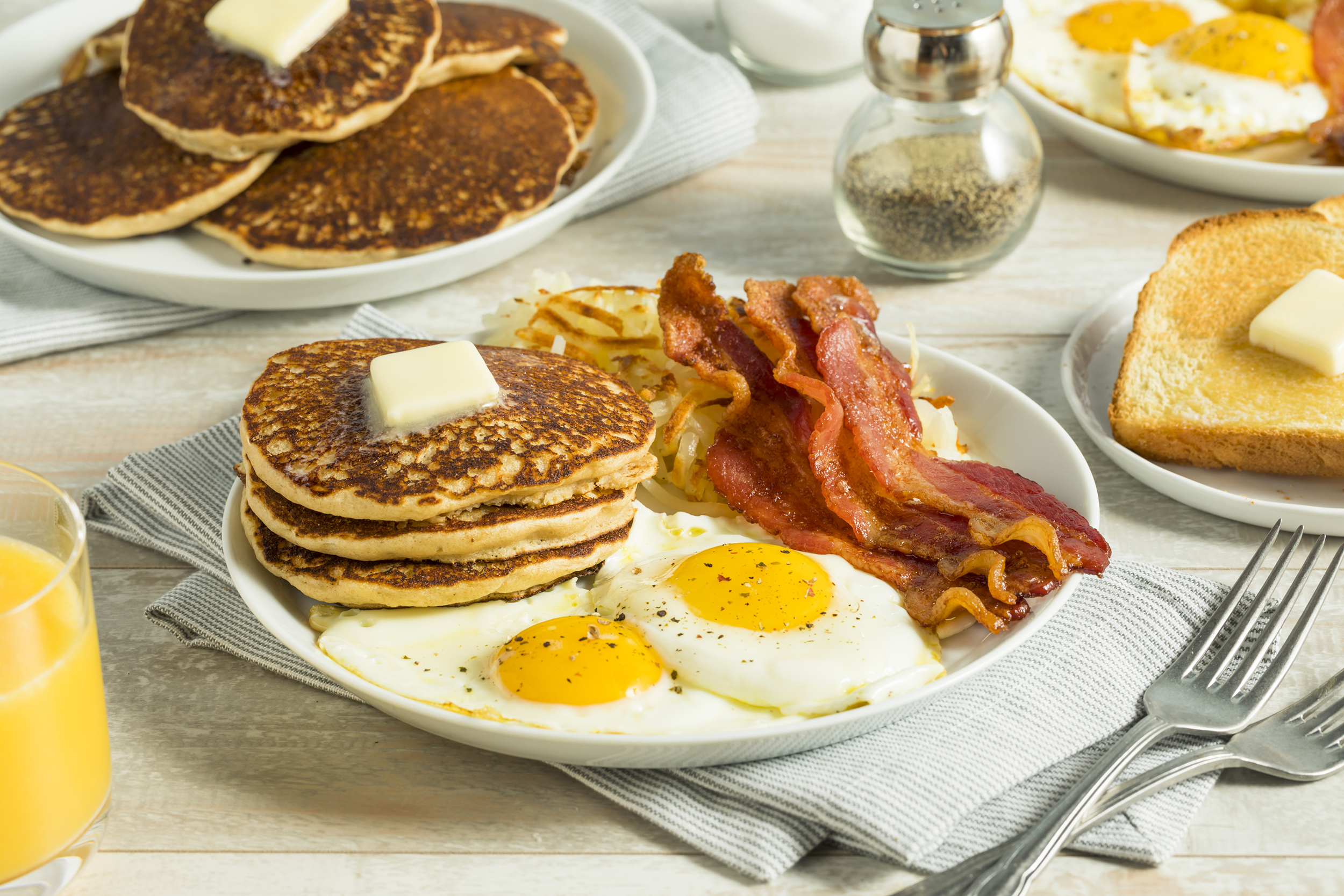Big breakfast with pancakes, bacon, and eggs
