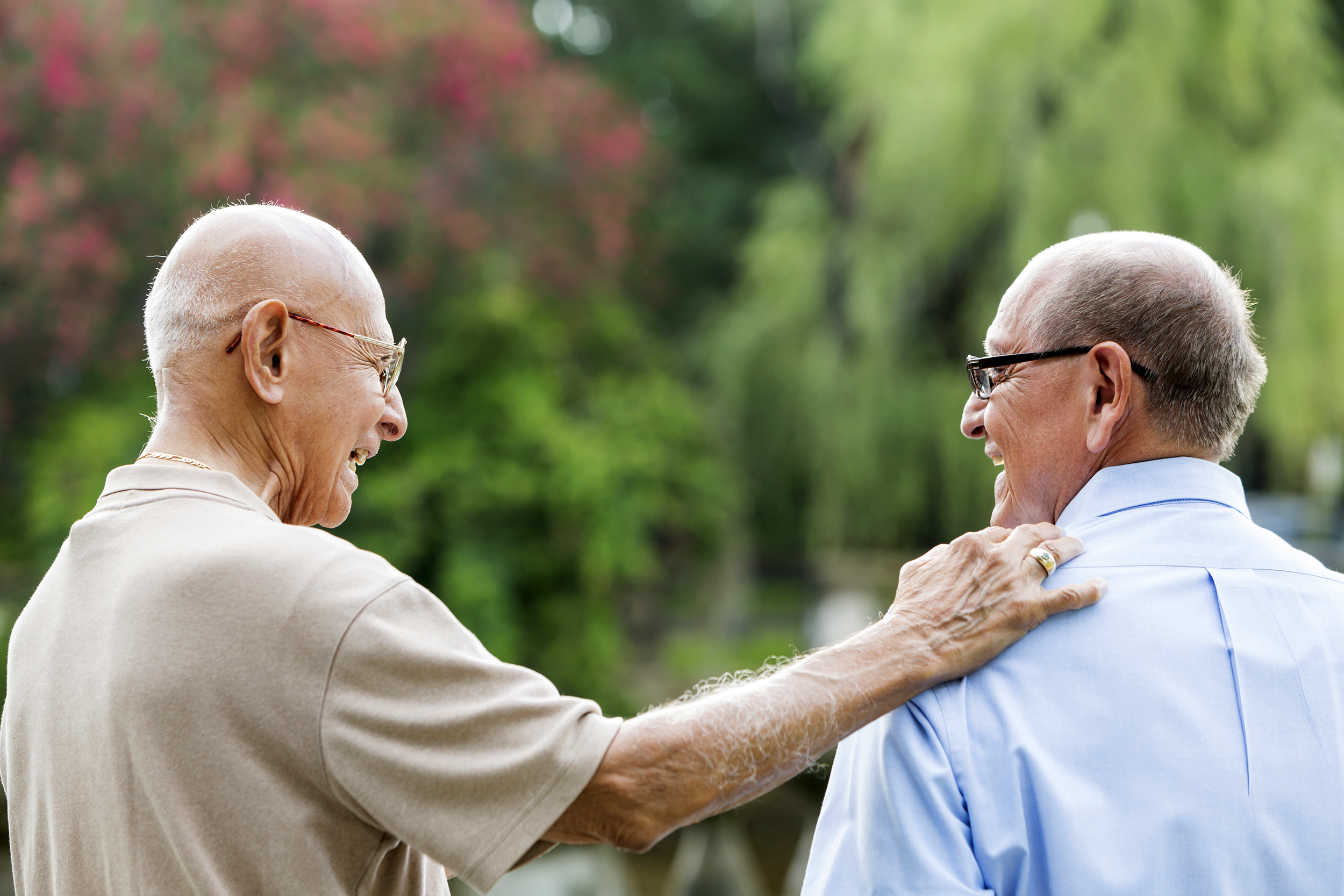 Senior man patting another senior man's shoulder