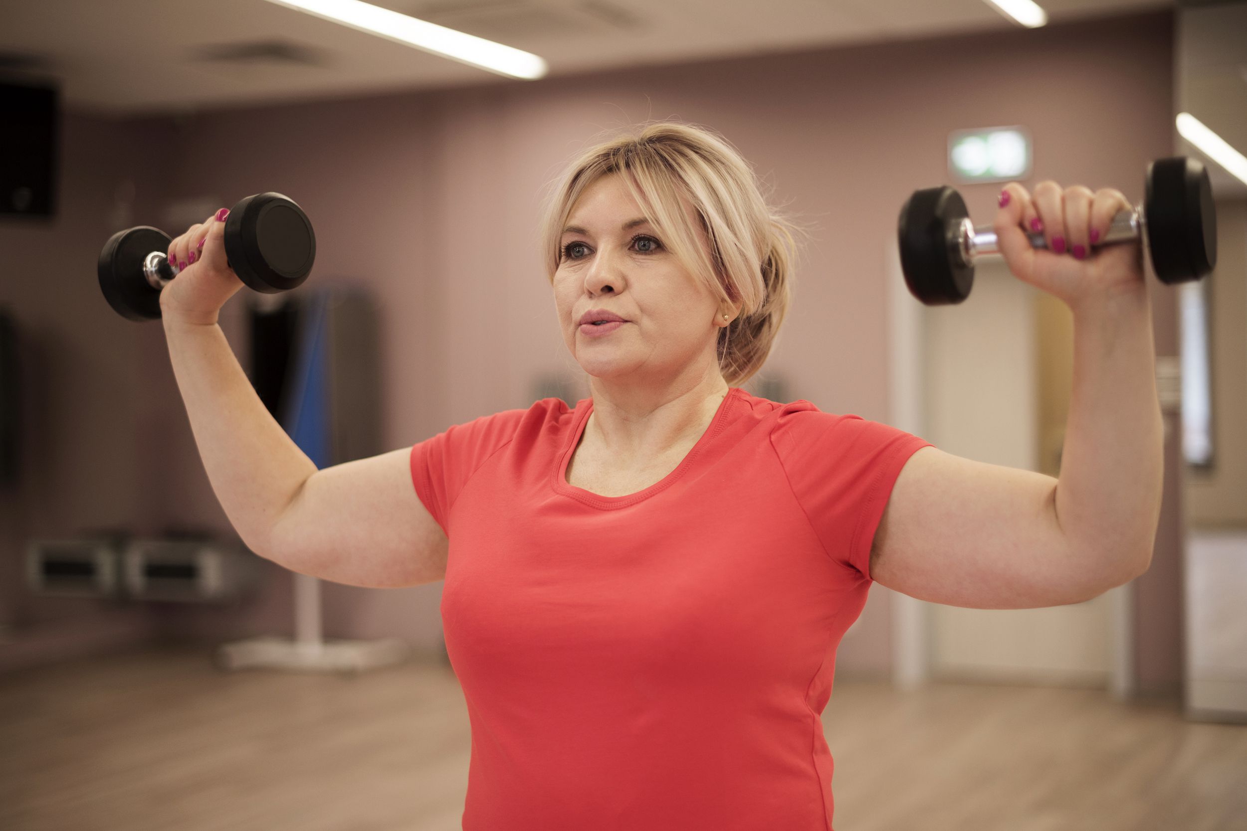 Woman breathing while lifting dumbbells