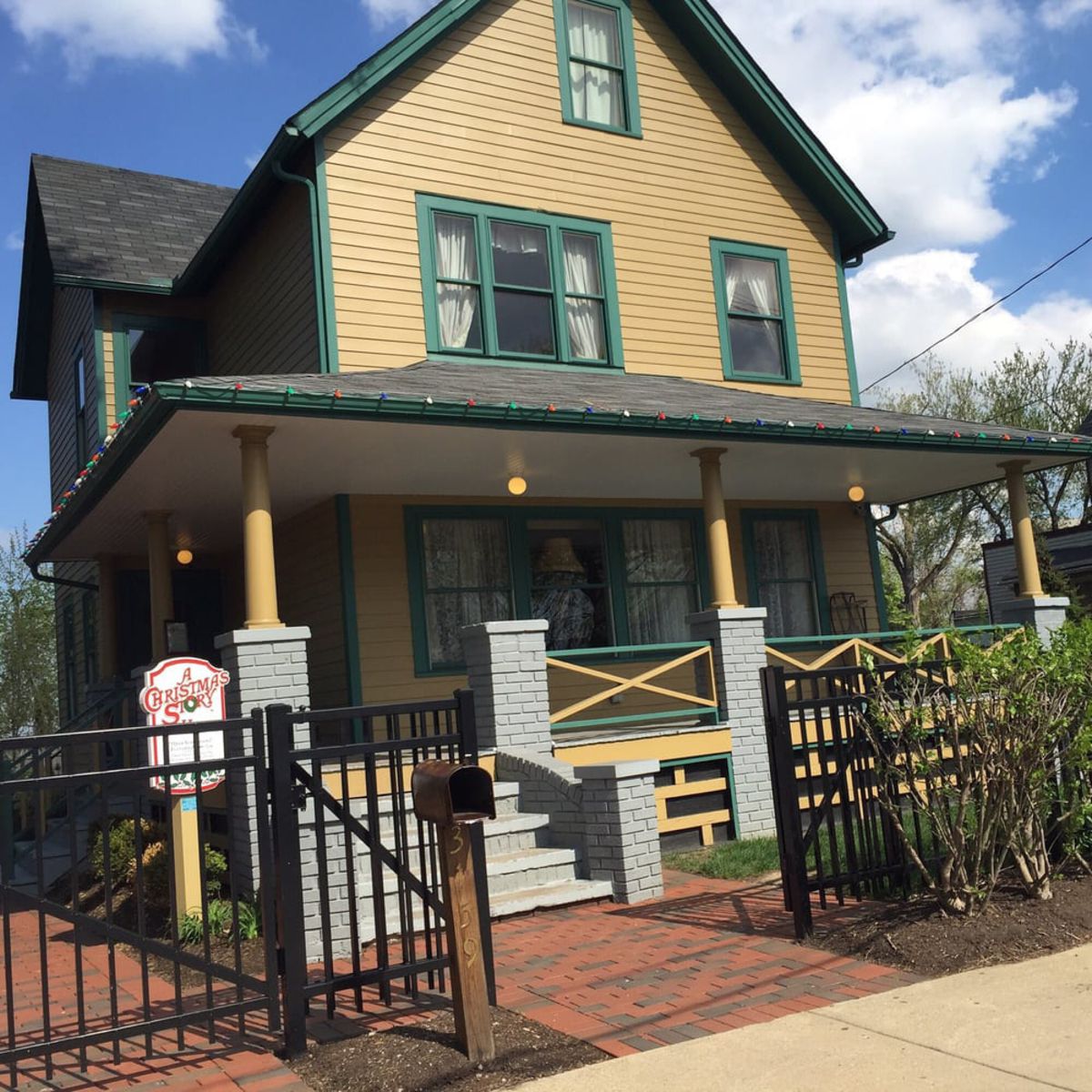 Front exterior of A Christmas Story House and Museum, Cleveland, Ohio, black fence surrounds the movie house, on a sunny day during summer