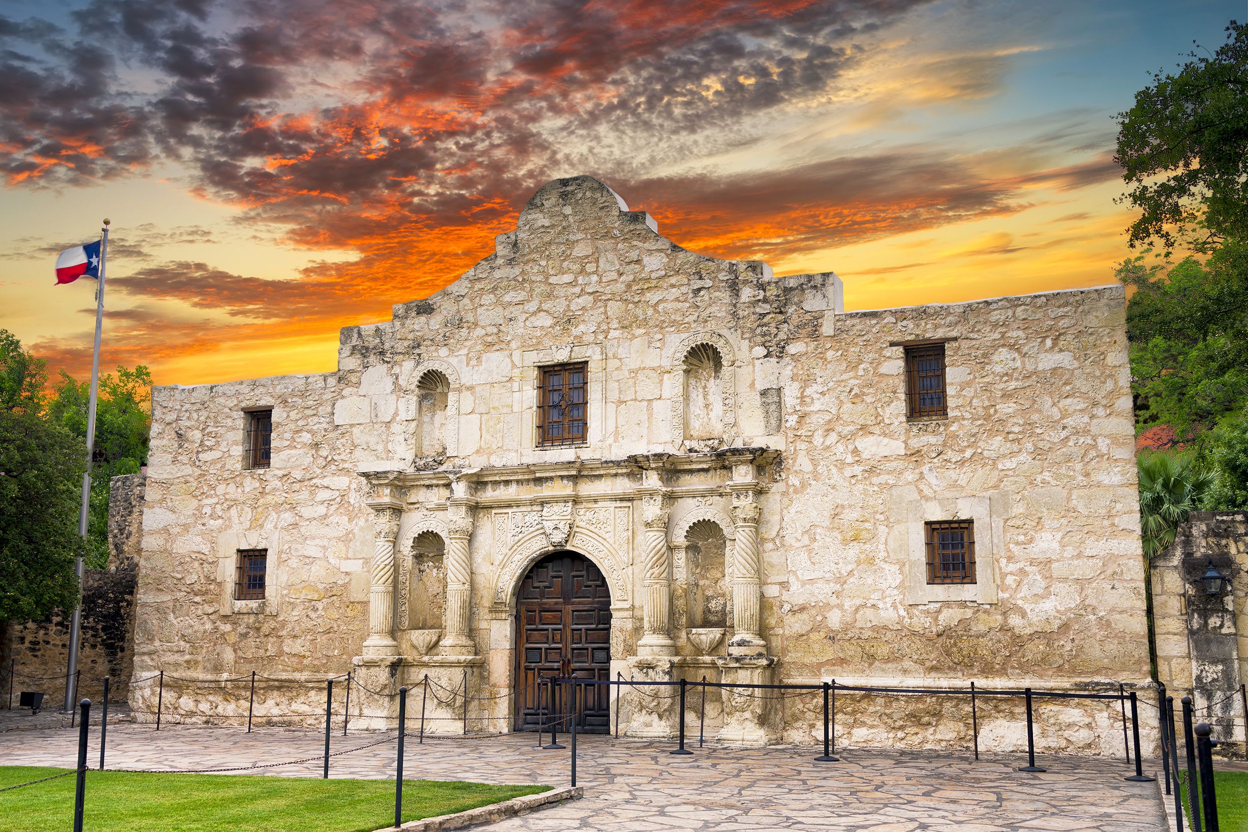 Front exterior of The Alamo, San Antonio, shortly after sunrise, surrounded by trees