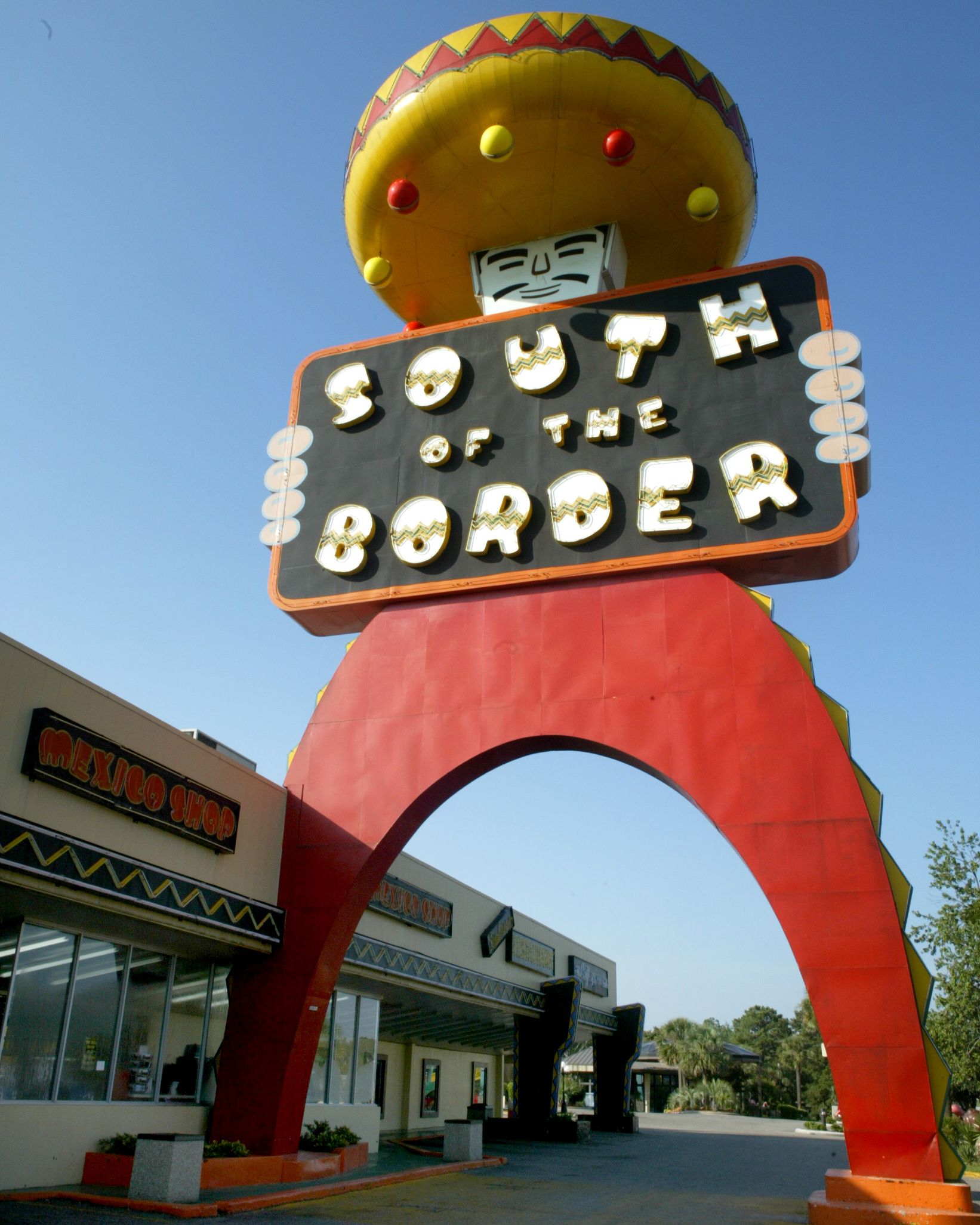 South of the Border, Hamer, South Carolina, Giant Statue of a Man Wearing Red Pants and a Yellow and Red Sombrero, rest stop on the left on a sunny day