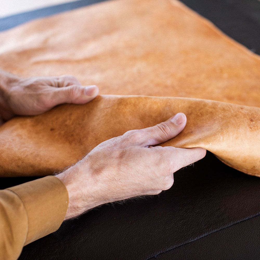 A hand touches Mycellium leather made by Mycoworks