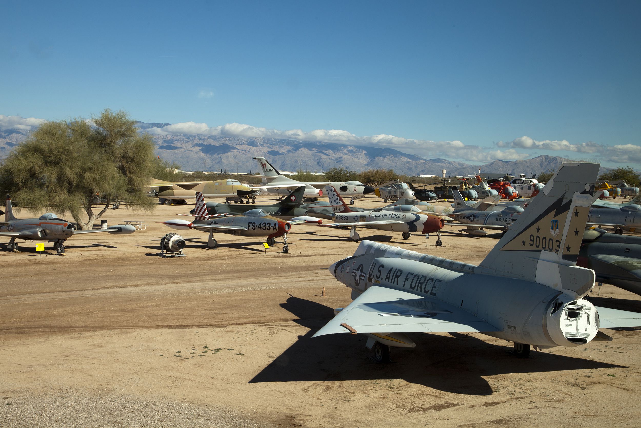 Several airplanes parked outside at Pima Air & Space Museum, Tucson, Arizona, mountains in the distance on a sunny day