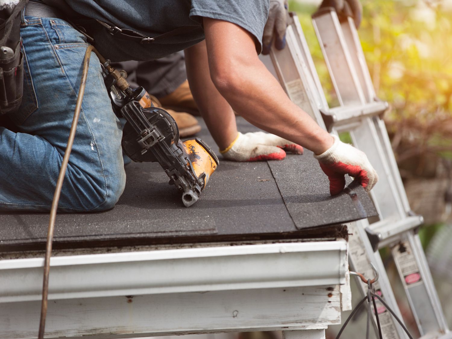 roofers installing a new roof on residential home. weatherlock material and brown asphalt roofing shingles