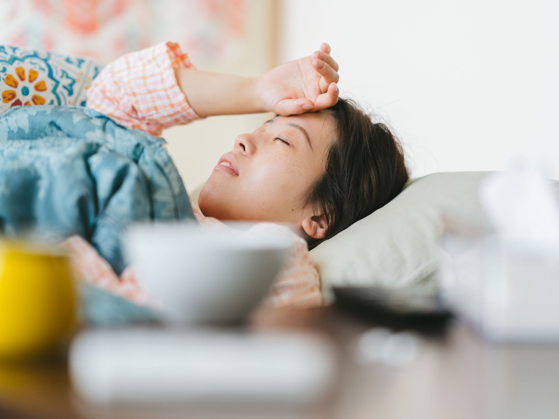 A women is feeling sick and sleeping on a sofa at home.