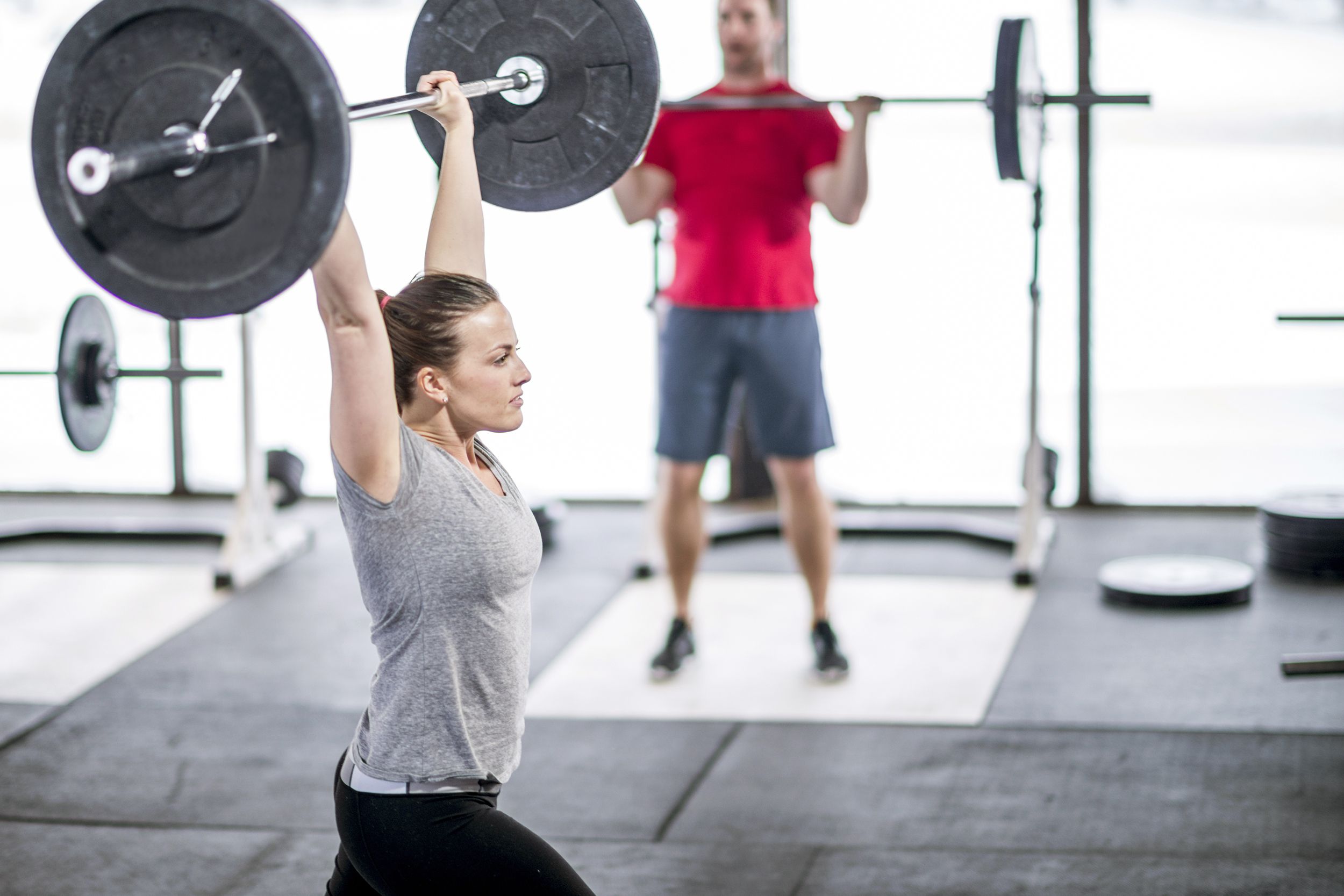 Woman pushing barbell over her head