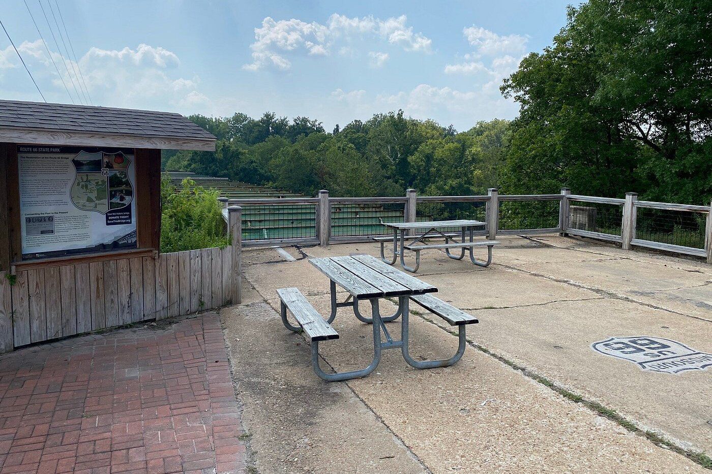 Route 66 State Park, Eureka, Missouri, park bench on concrete overlooking trees, on a sunny day during summer