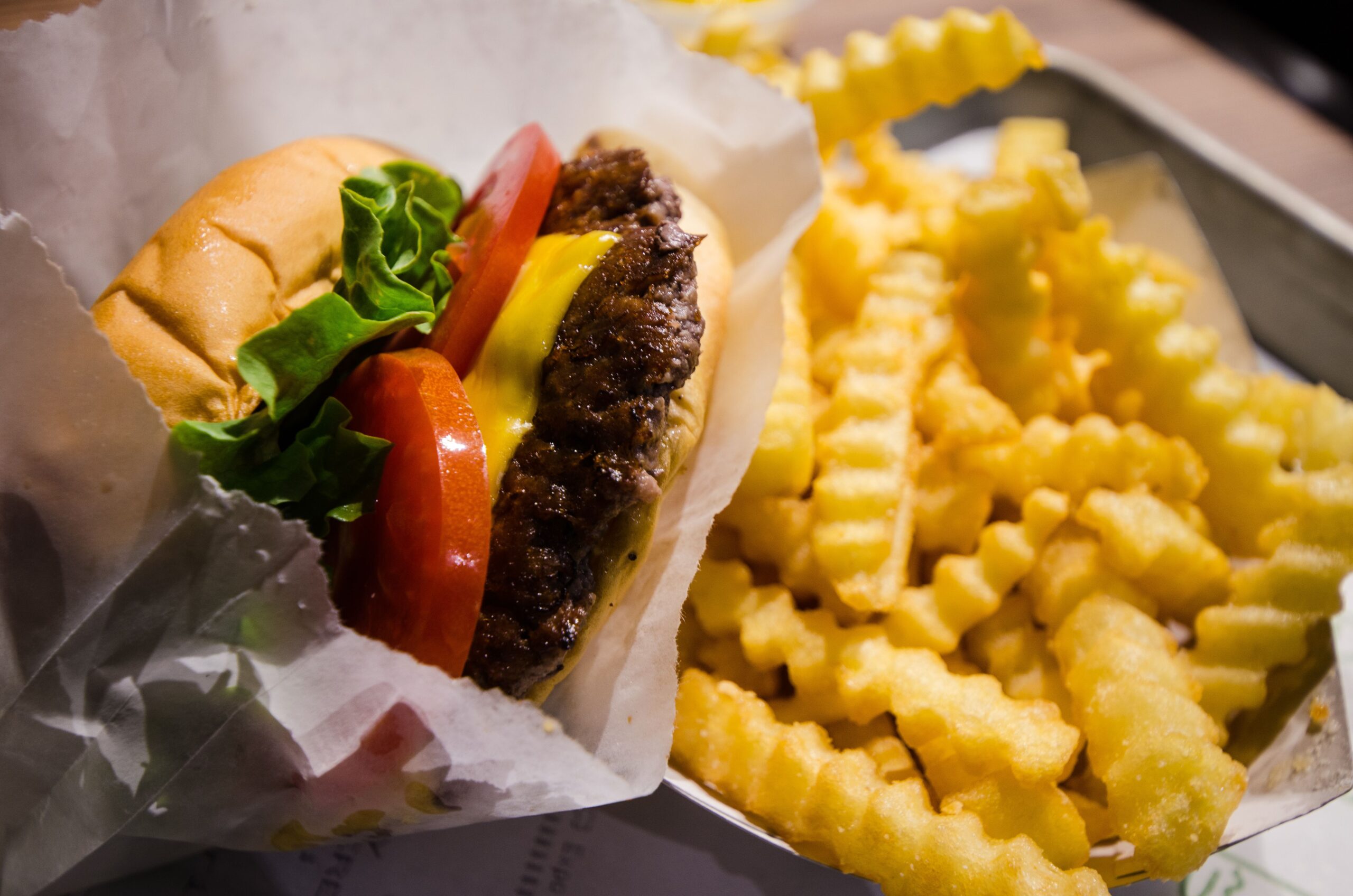 Cheeseburger with fresh lettuce and tomatoes with a side of fries.